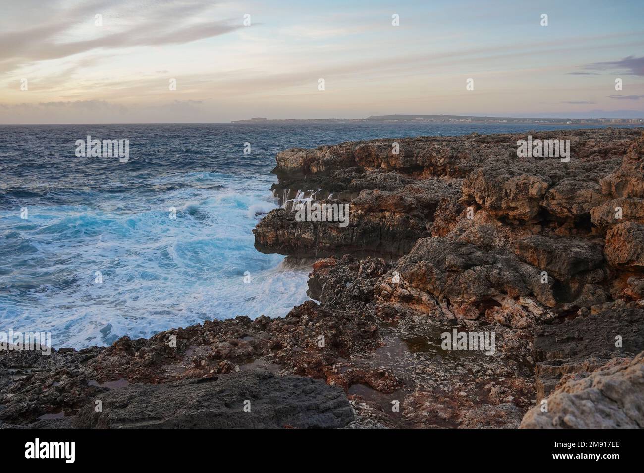 Onde alte, mare mosso, costa rocciosa vicino a Ciutadella, Minorca, isole Baleari, Spagna. Foto Stock