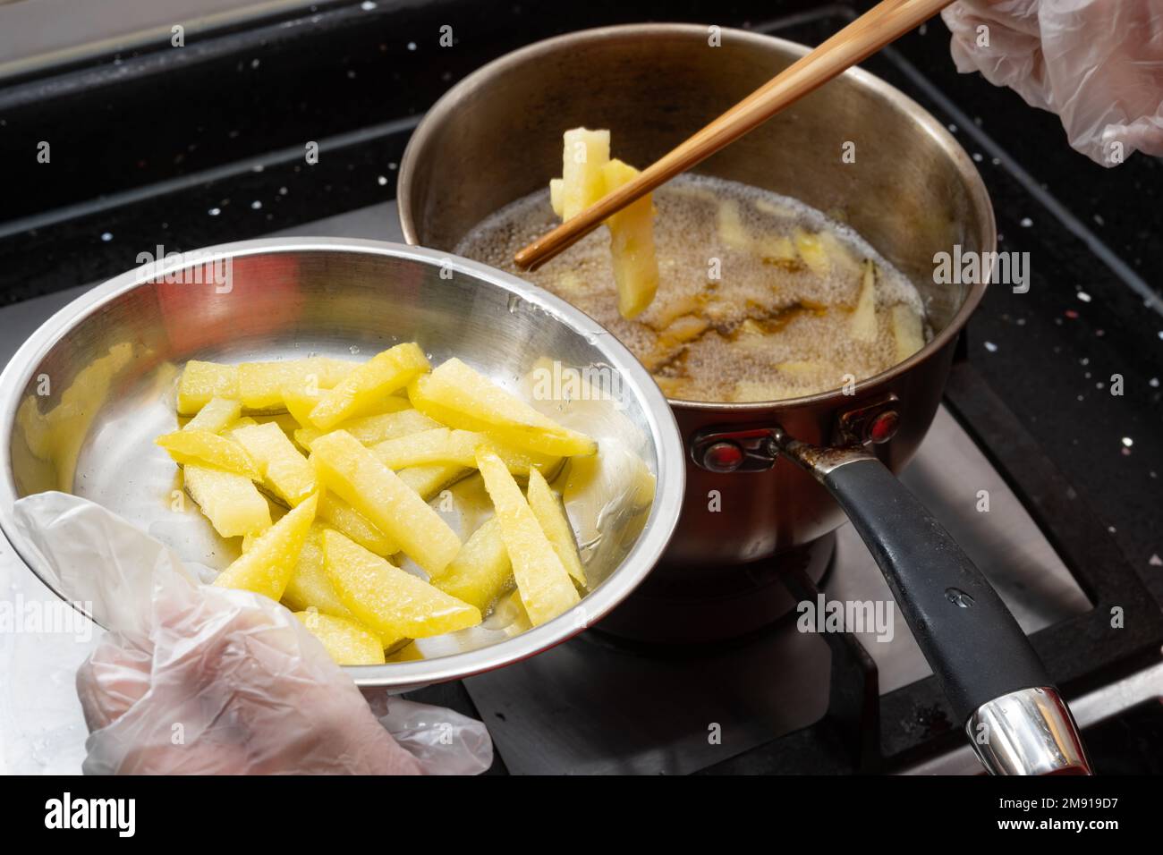 capretto che fa le patatine fritte in una cucina Foto Stock