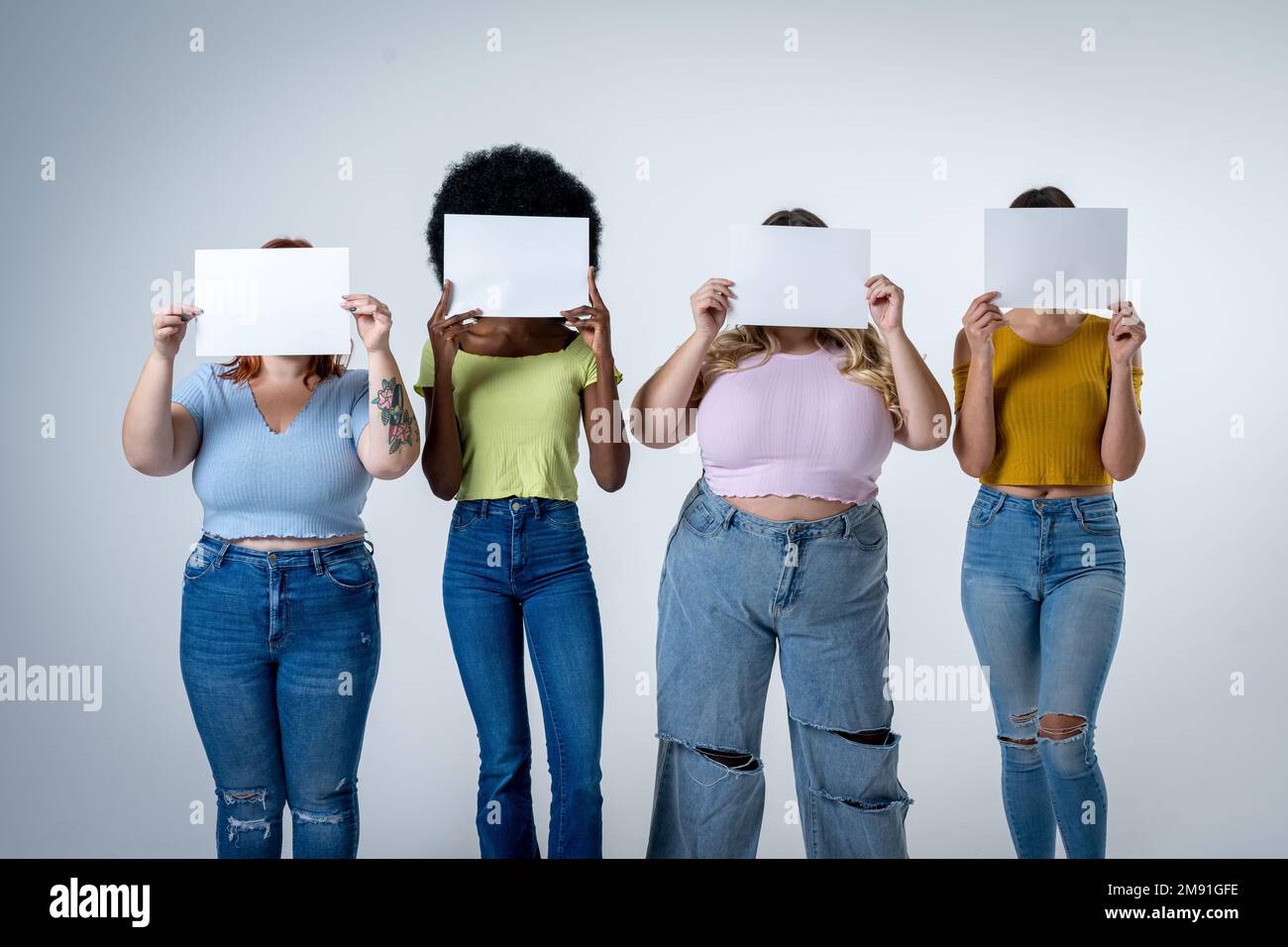 Le donne che tengono bianco bordo sopra la faccia, il concetto positivo del corpo, lo spazio della copia sui segni vuoti per scrivere che cosa desiderate Foto Stock