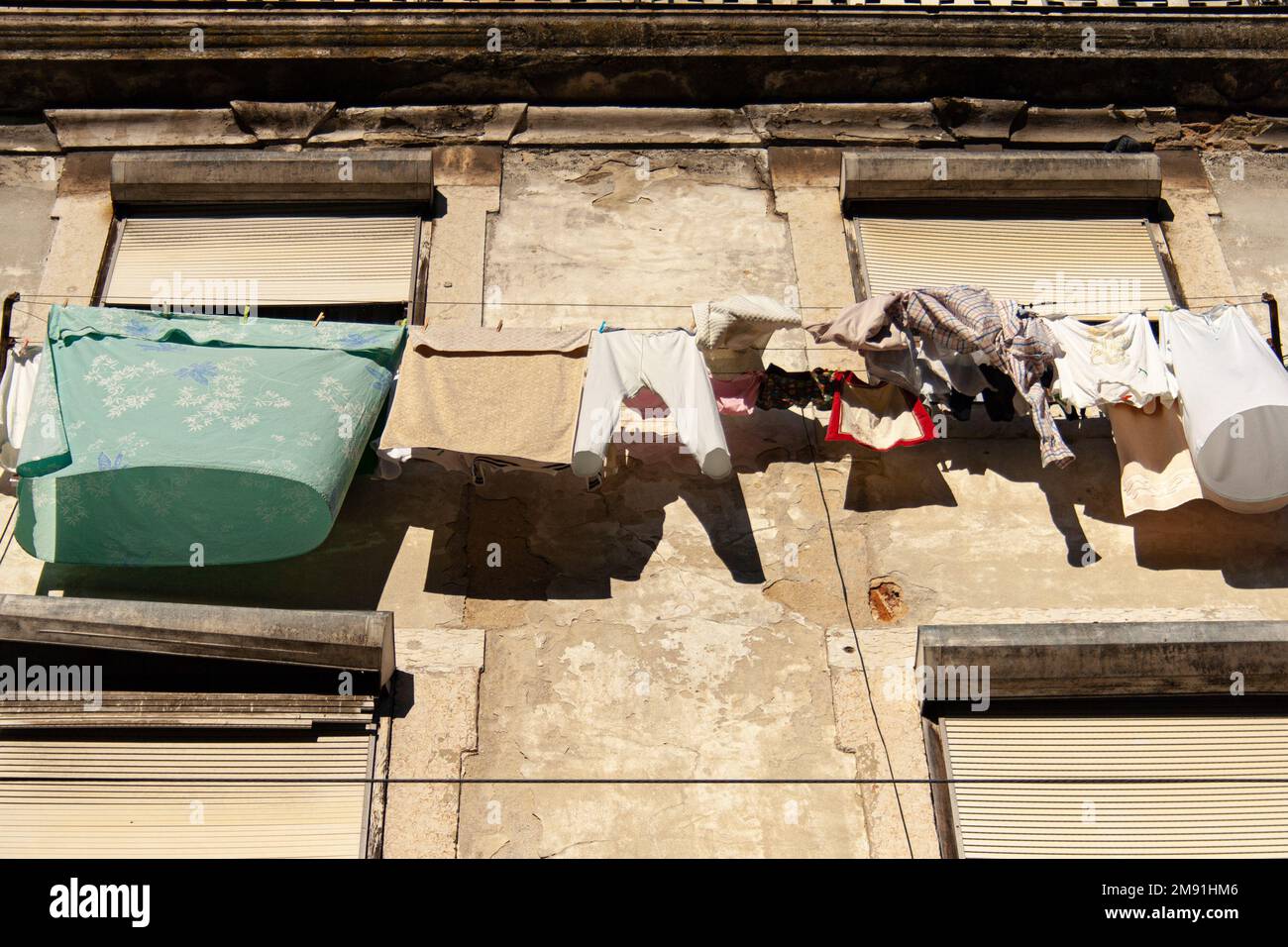 Un basso angolo di tiro di vestiti disposti in un edificio delapidayed, Lisbona Foto Stock