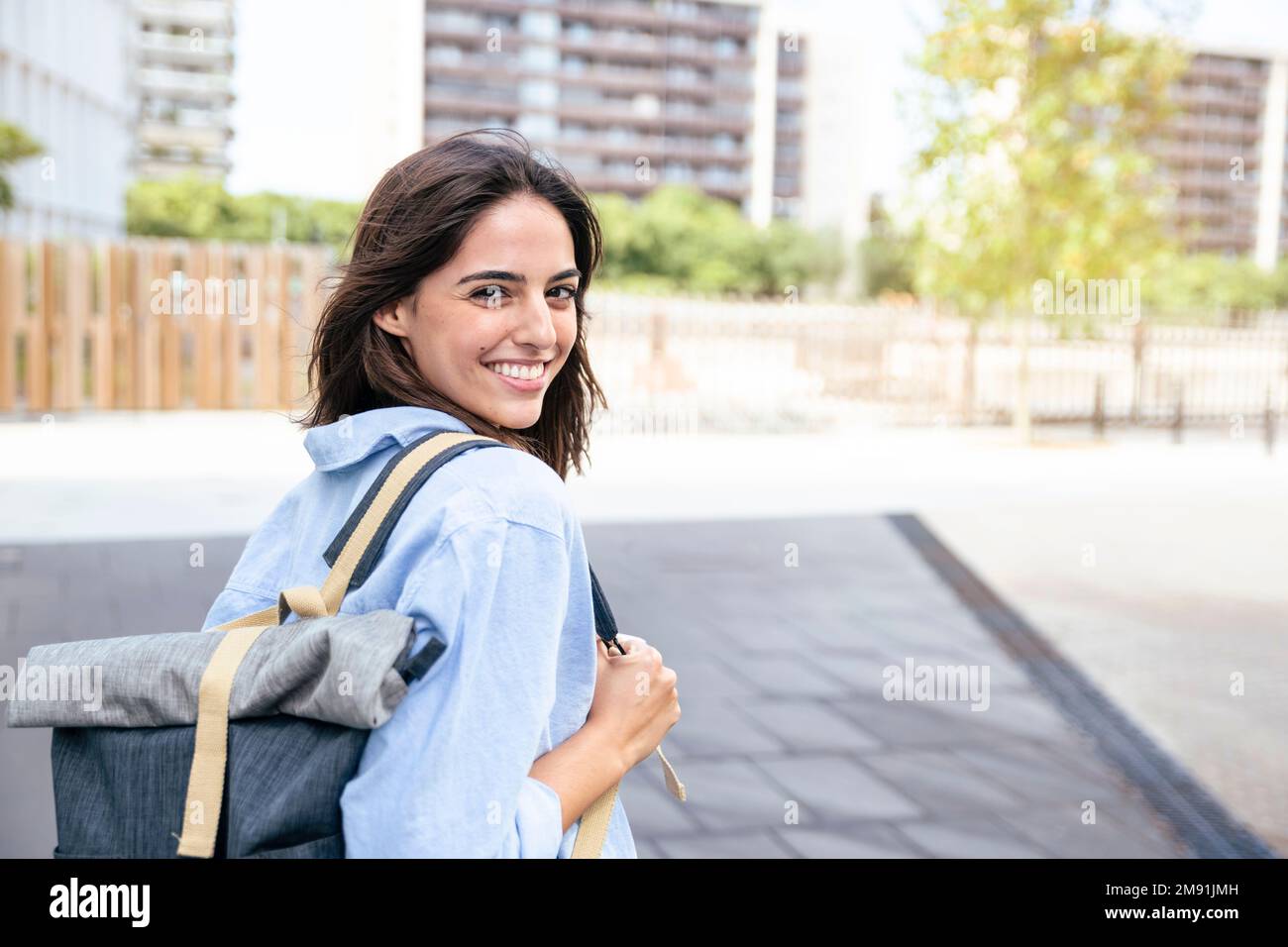 Allievo felice con lo zaino nel campus. Ritratto di donna sorridente guardando la macchina fotografica con bakcpack. Foto Stock