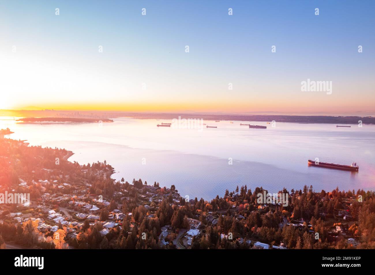 Vista aerea di West Vancouver e Vancouver, paesaggio urbano dell'oceano all'alba, navi da carico, Burrard Inlet, riprese di droni. Foto Stock