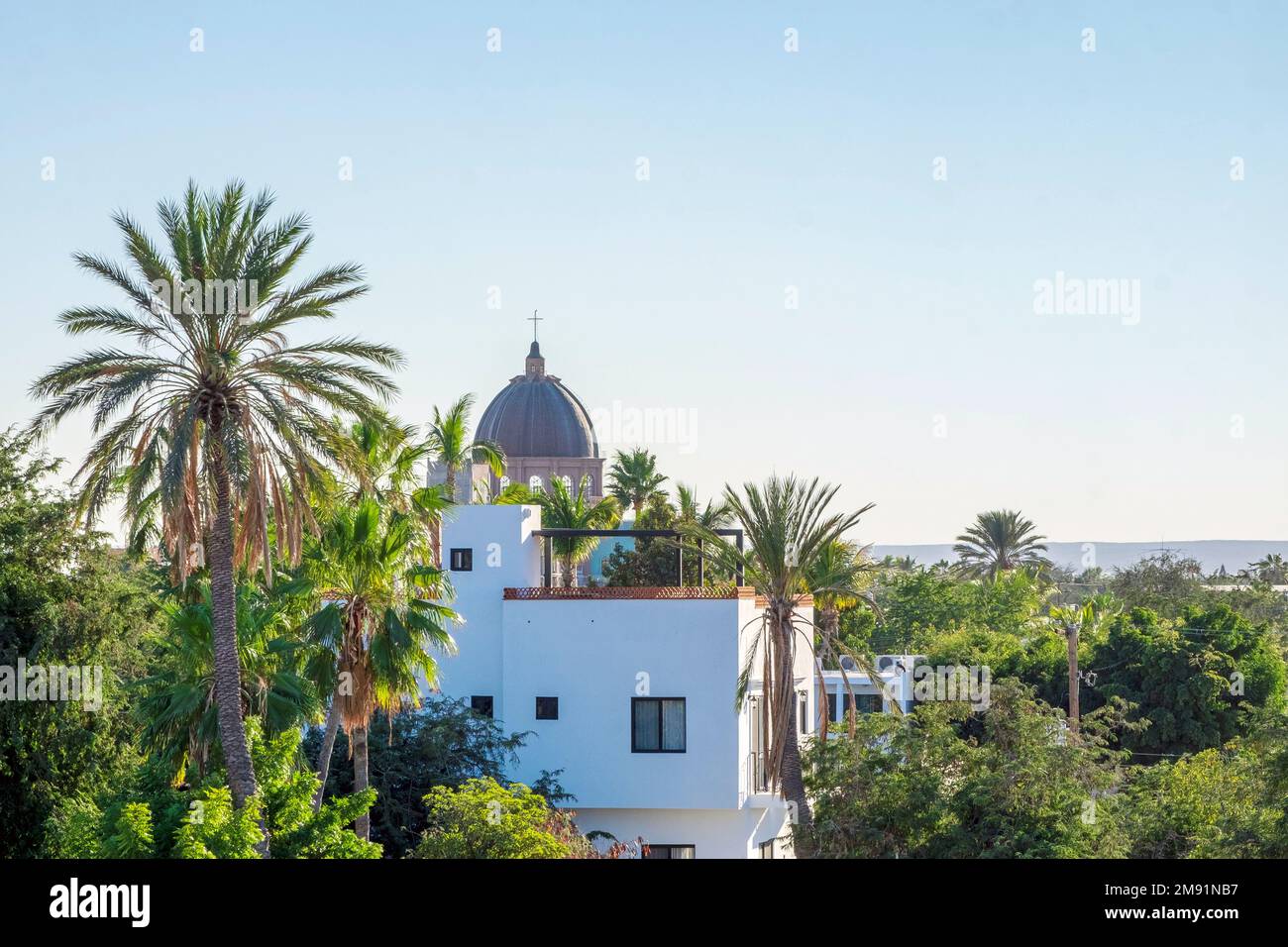 La Paz, Baja California, Messico, nuova casa, balcone, palme, cupola della chiesa in distanza Foto Stock
