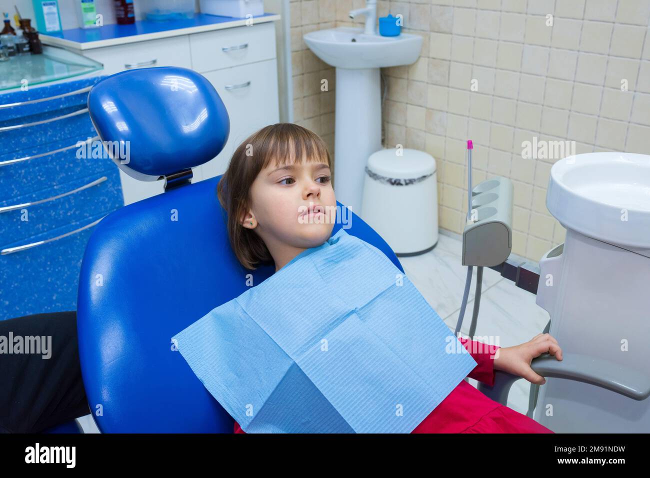 Un piccolo paziente è seduto in un dentista ufficio Foto Stock