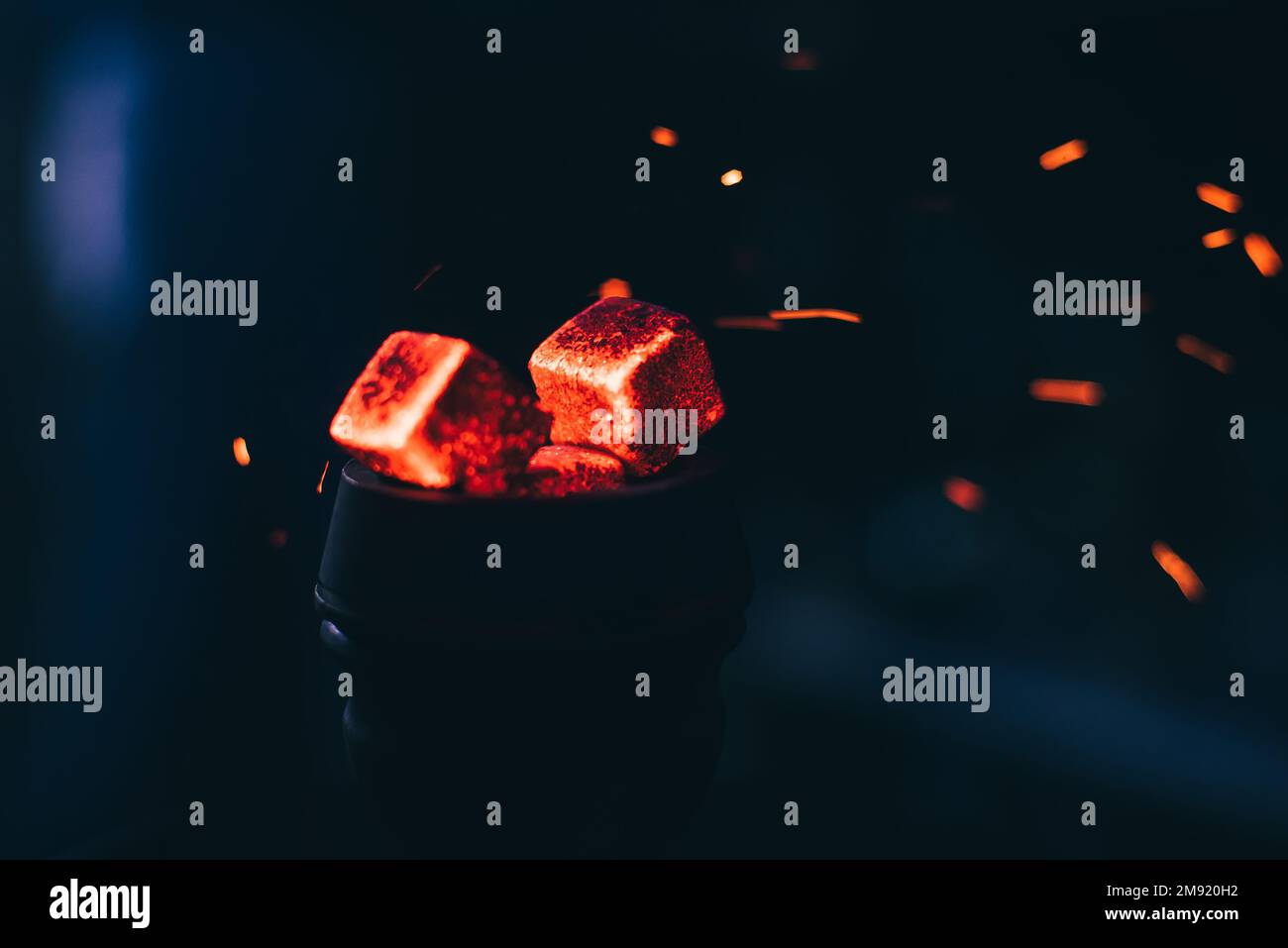 Carboni rossi caldi con scintille di hookah in ciotola di metallo per il fumo di Shisha e il rilassamento asiatico tradizionale primo piano Foto Stock