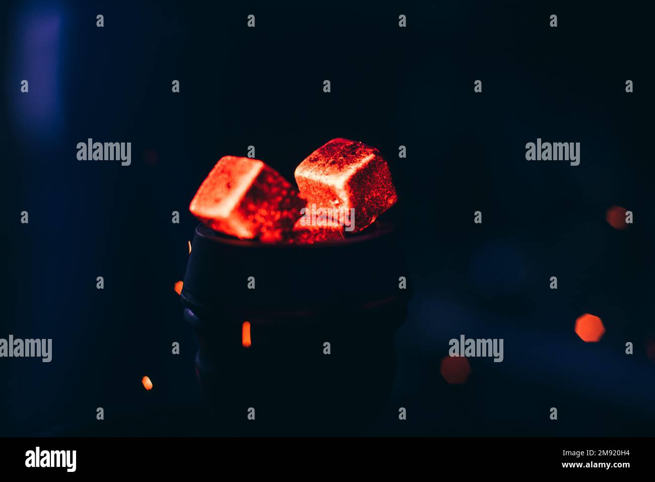 Carboni rossi caldi con scintille di hookah in ciotola di metallo per il fumo di Shisha e il rilassamento asiatico tradizionale Foto Stock