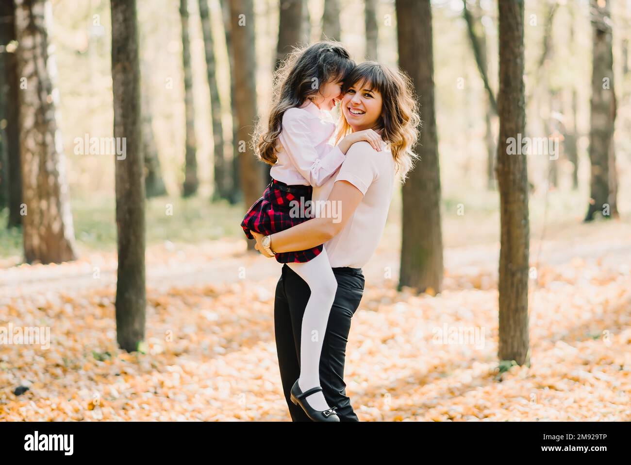madre felice con la figlia tra le braccia sorridendo e ridendo Foto Stock