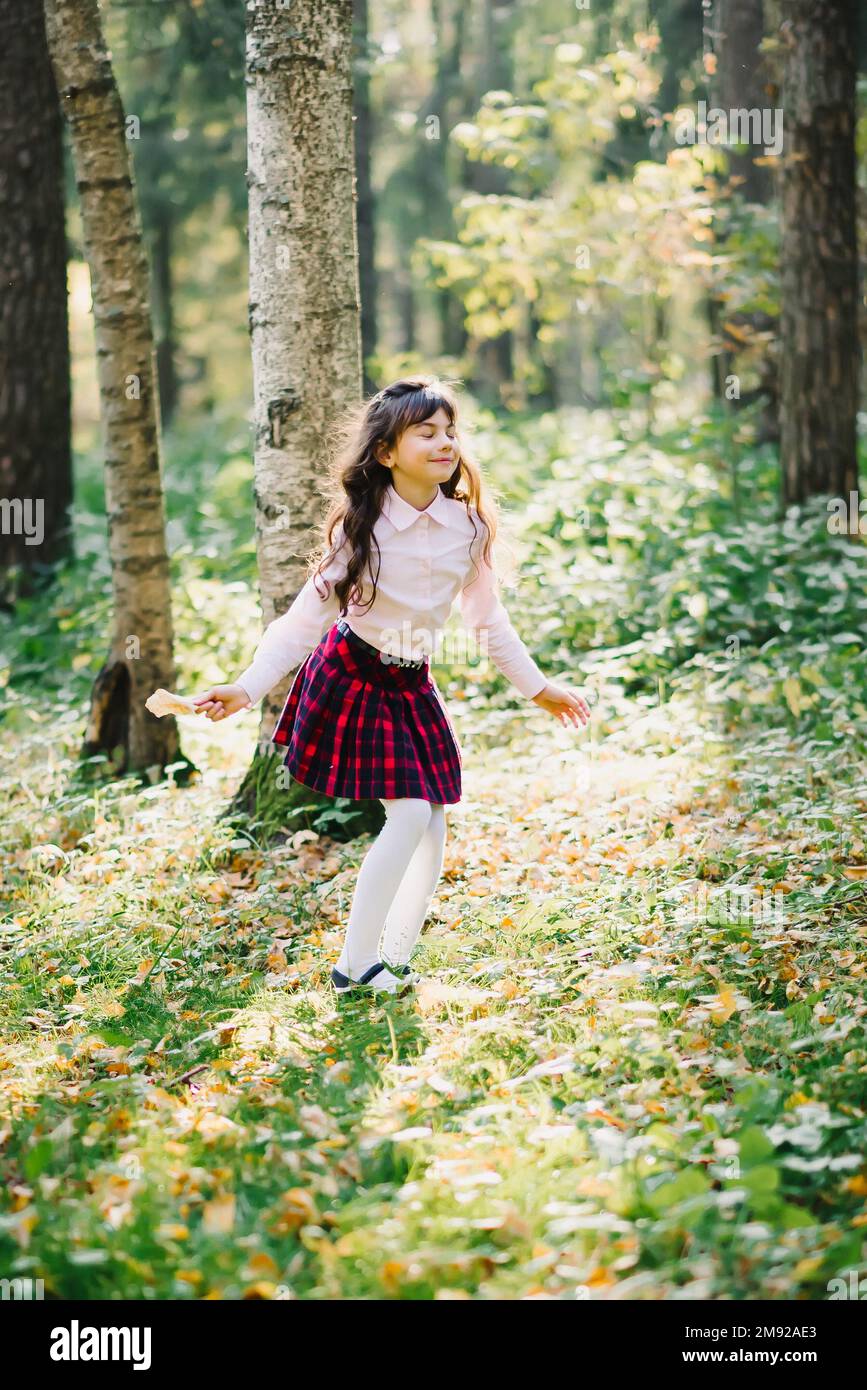 Felice bella ragazza brunetta sta girando e godendosi nel Parco in autunno Foto Stock