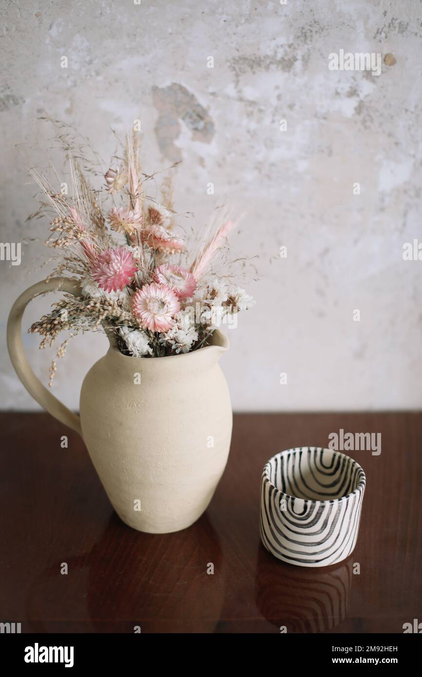 Composizione minimalistica di fiori secchi in vaso ceramico come decorazione domestica. Foto Stock