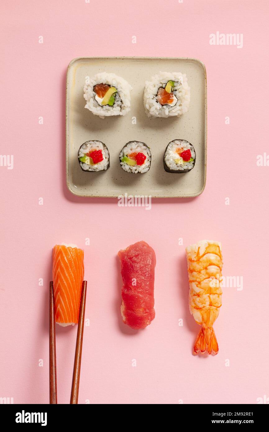 Piatto di vari panini di sushi posti su piatti con chopsticks e salsa di  soia su sfondo rosa Foto stock - Alamy