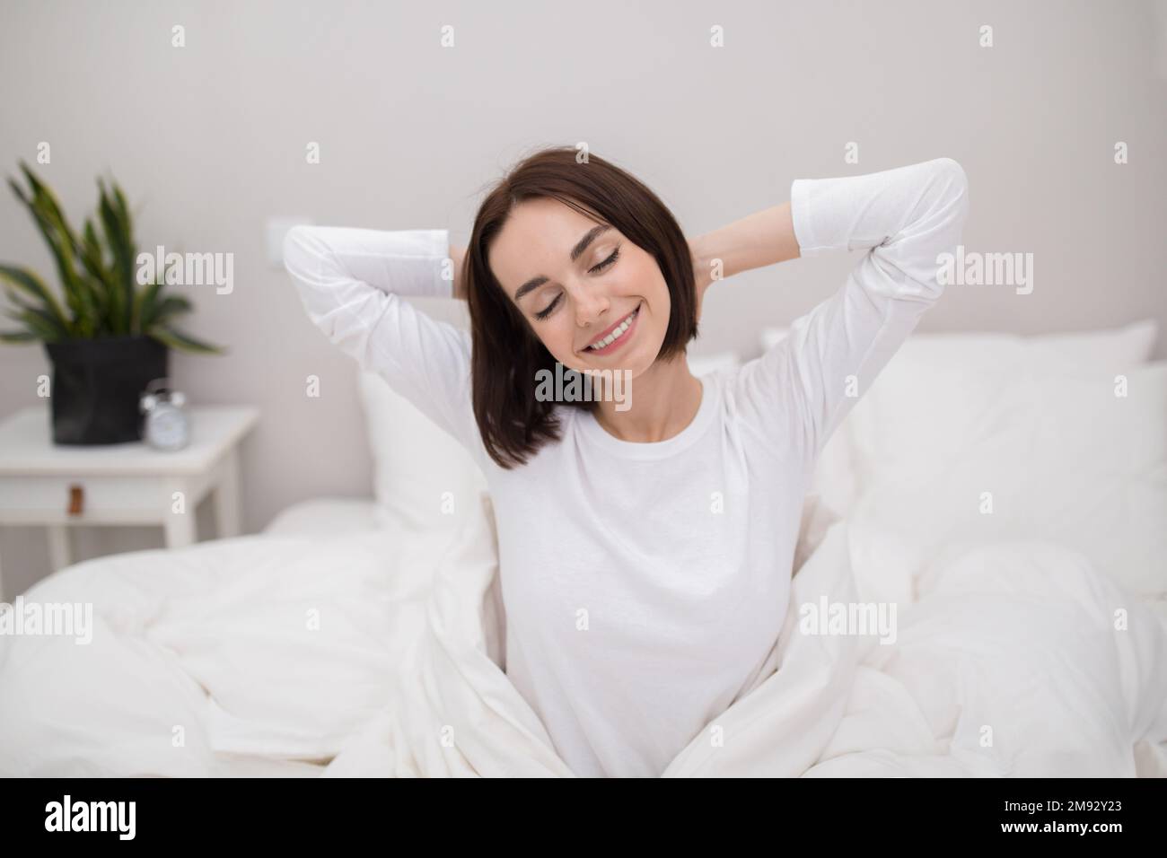 Giovane donna ben riposata che si sveglia al mattino, all'interno della camera da letto Foto Stock