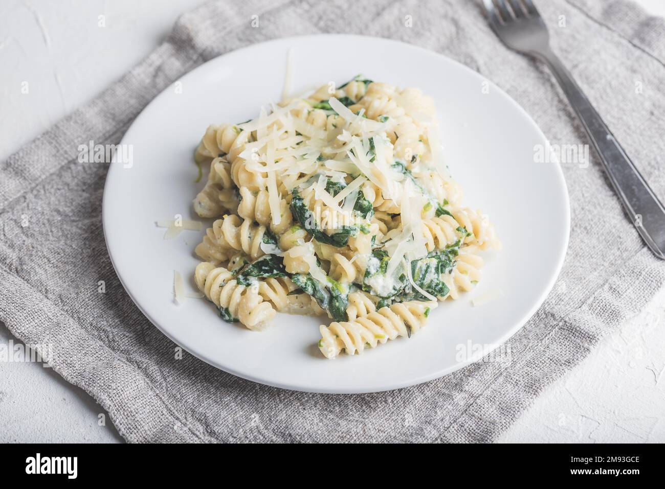 Pasta cremosa di Fusilli di spinaci con ricotta e parmigiano sul Bianco Piastra Foto Stock