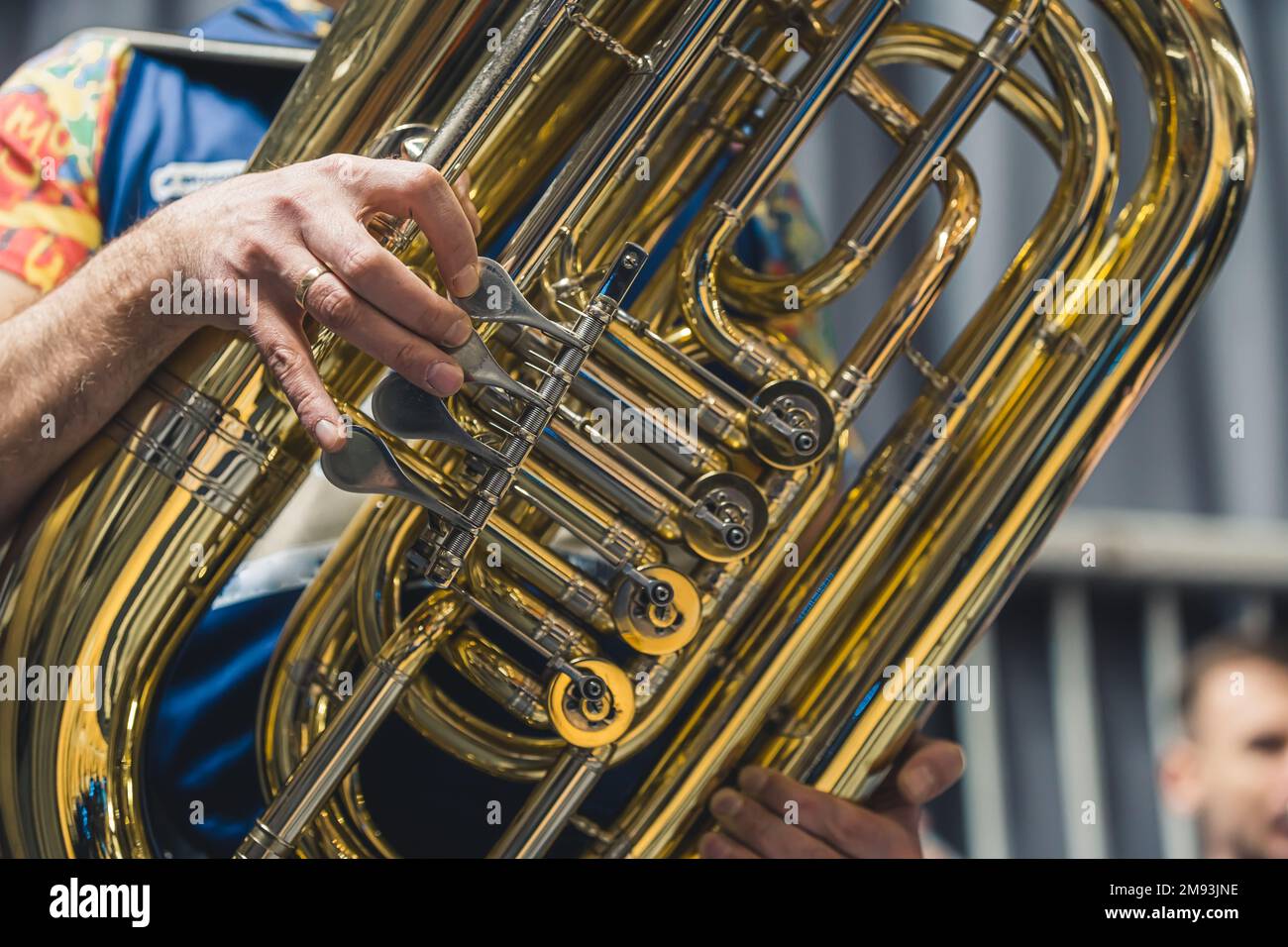 Un primo piano di una parte di una tuba con una persona sullo sfondo. Foto di alta qualità Foto Stock Un primo piano di una parte di una tuba con una persona sullo sfondo. Foto di alta qualità Foto Stock