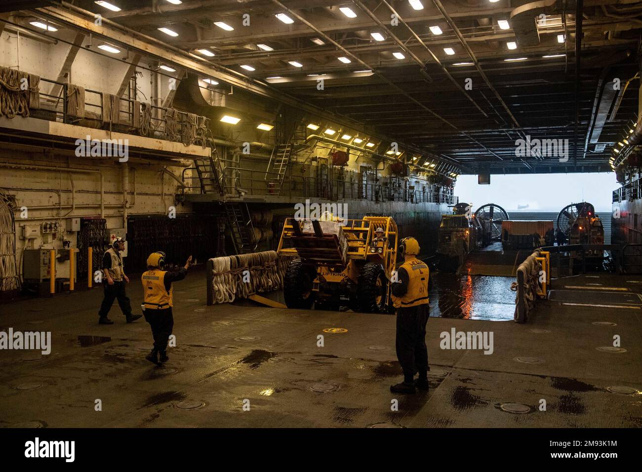 MARE DELLE FILIPPINE (13 gennaio 2023) - i marinai assegnati alla nave portuale di trasporto anfibio USS Green Bay (LPD 20) e i marines assegnati alla 31st Marine Expeditionary Unit (MEU) scaricano un cuscino d'aria per imbarcazioni da sbarco (LCAC) dalla Naval Beach Unit (NBU) 7 nel ponte dei pozzi della nave. Green Bay, parte dell'Expeditionary Strike Group 7, insieme al 31st MEU, opera nell'area di responsabilità della flotta degli Stati Uniti 7th per migliorare la sua interoperabilità con alleati e partner e fungere da pronta forza di risposta per difendere la pace e la stabilità nella regione dell'Indo-Pacifico. (STATI UNITI Foto Navy di Mass Communication Speci Foto Stock