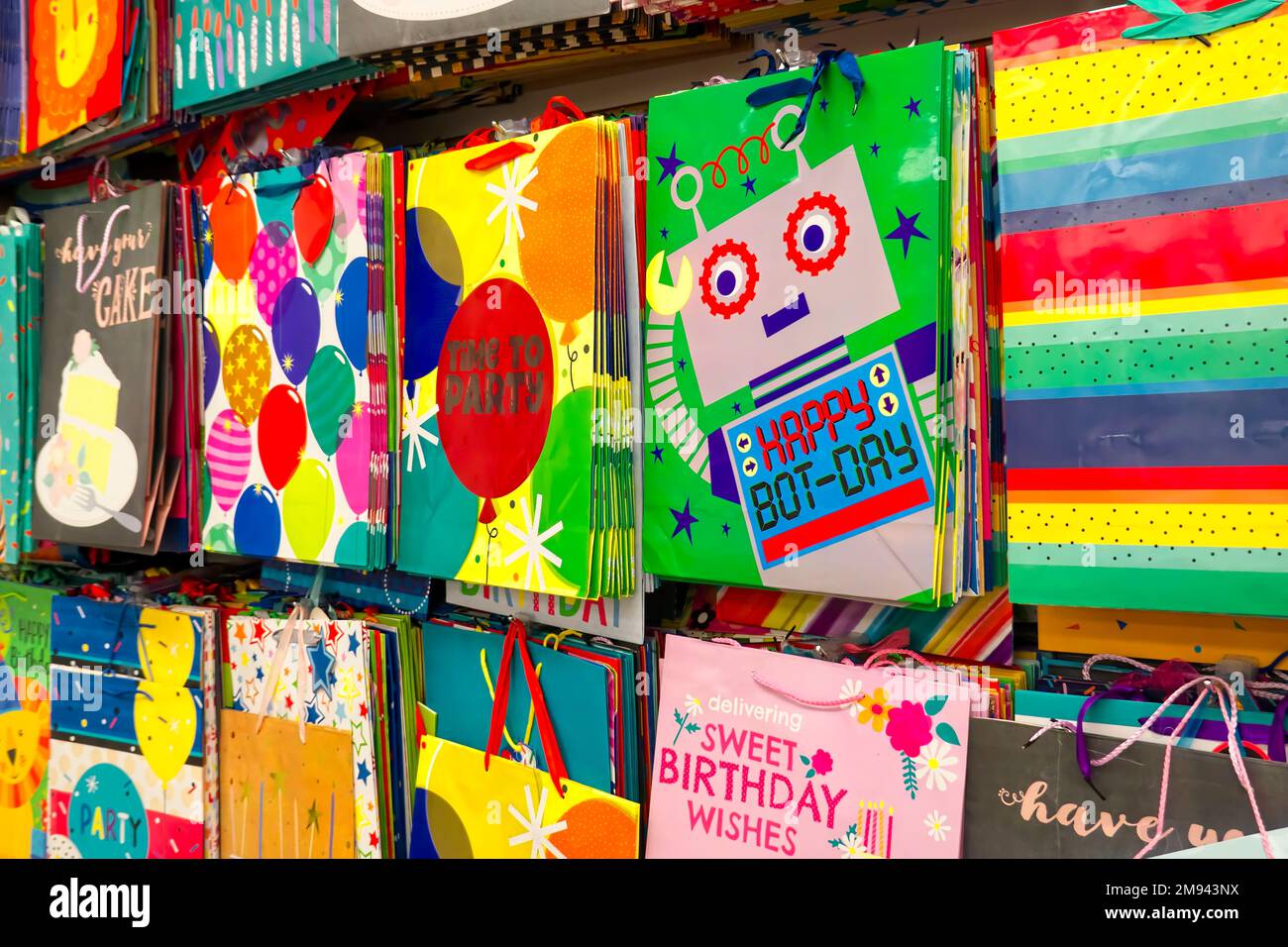 Mostra del negozio di borse regalo colorate appese a una parete - forniture per feste. Metro Vancouver, B. C., Canada. Foto Stock