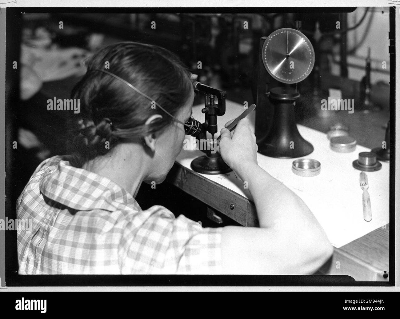 [Senza titolo] (Donna con Loupe e pinzette) Lewis Wickes Hine (americano, 1874-1940). , 1936-1937. Fotografia in argento gelatina, 4 3/4 x 7 1/4 pollici (12,1 x 18,4 cm). Fotografia 1936-1937 Foto Stock