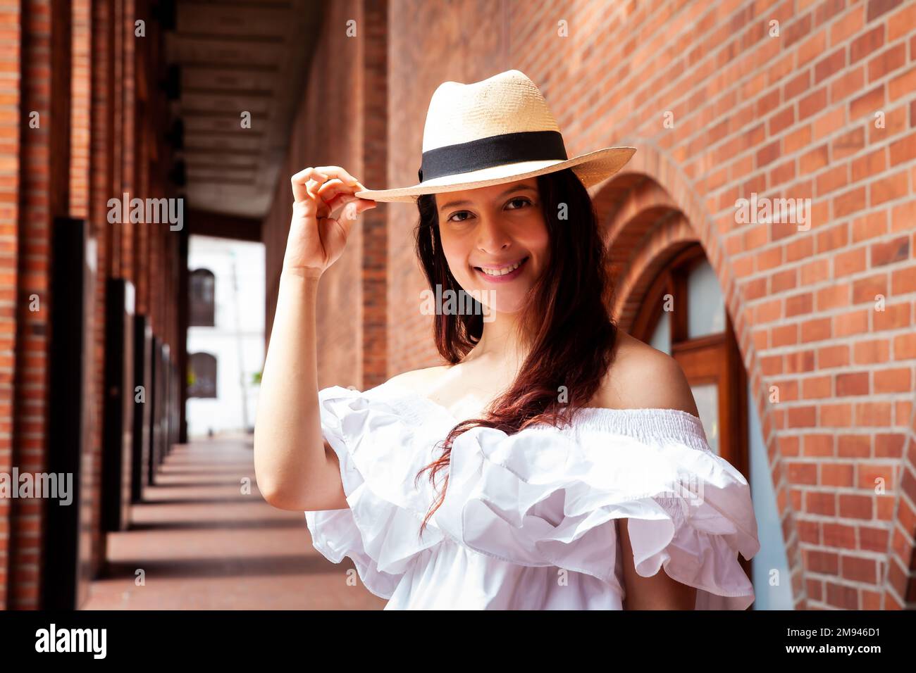 Bella giovane donna che indossa un cappello tradizionale tipico della piccola città di Aguadas in Colombia chiamato un cappello Aguadeño. Foto Stock