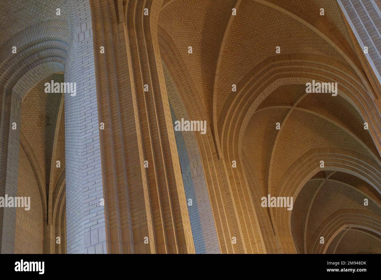 Particolare della volta in mattoni color crema, arco, parete di costole, colonna ed elemento clerestorio sul soffitto della chiesa protestante espressionista a Copenaghen, Danimarca. Foto Stock