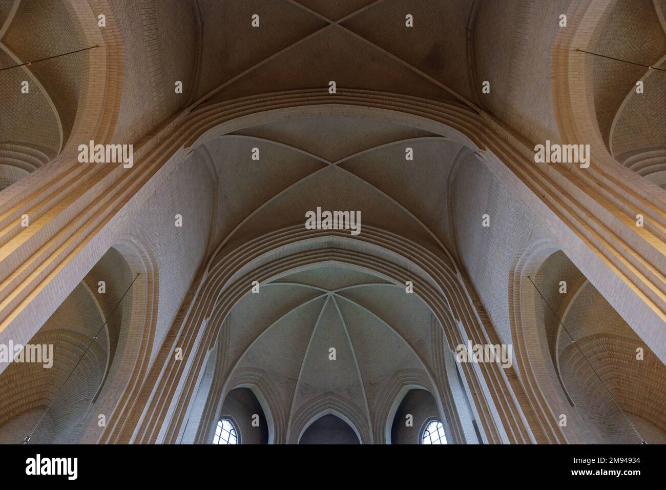 Particolare della volta in mattoni color crema, arco, parete di costole, colonna ed elemento clerestorio sul soffitto della chiesa protestante espressionista a Copenaghen, Danimarca. Foto Stock