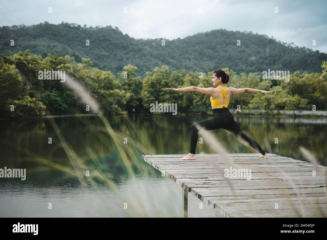Donna che pratica yoga sul ponte a Lake.Yoga e concetto di stile di vita sano. Foto Stock