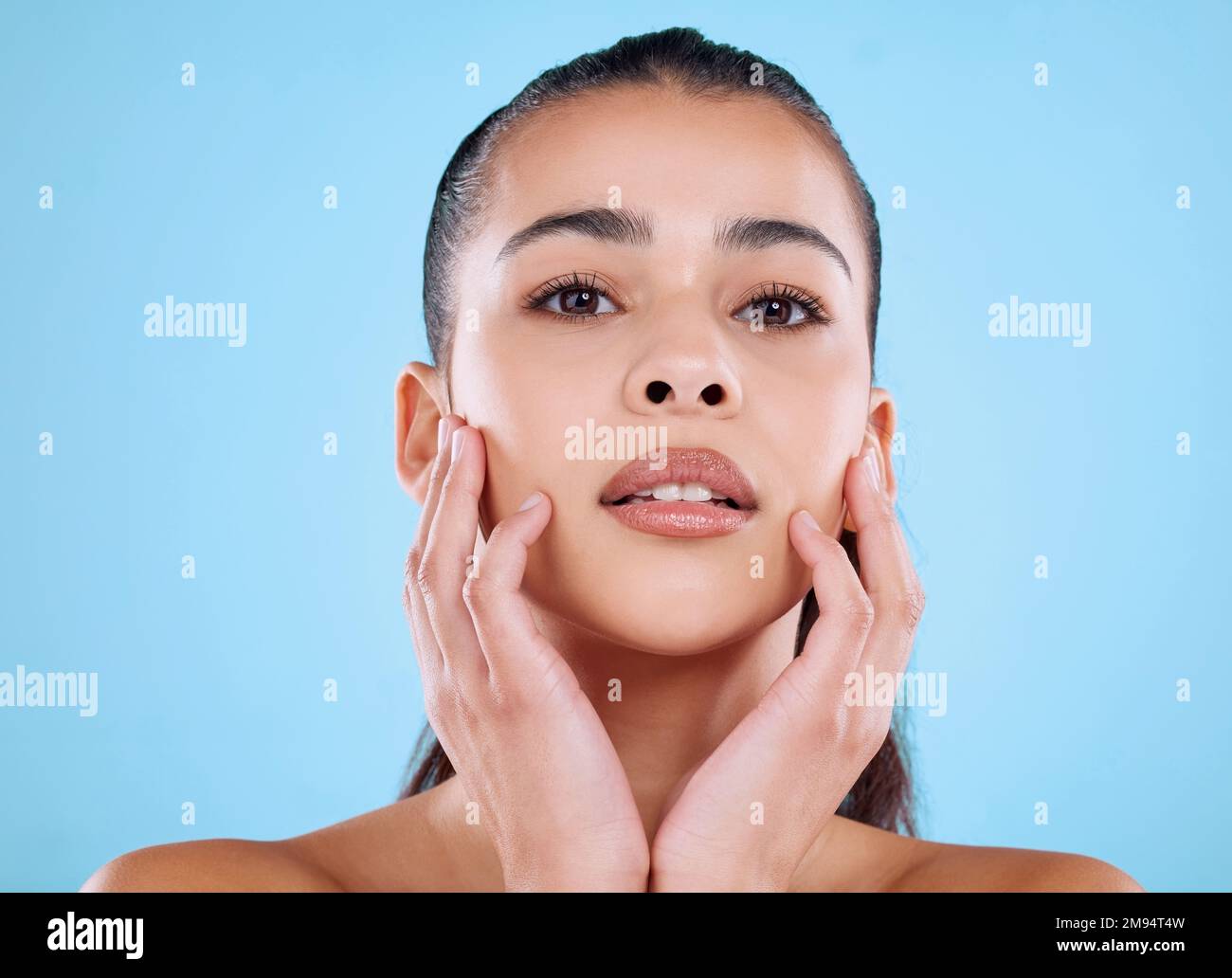 È una sensazione meravigliosa. Studio ritratto di una giovane donna attraente che si posa su uno sfondo blu. Foto Stock