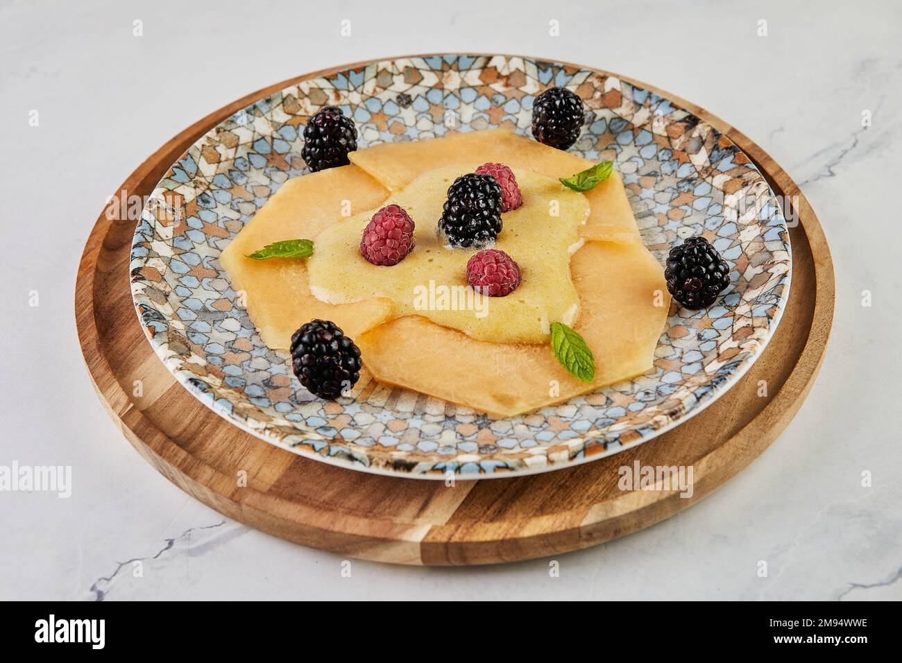 Carpaccio di melone con lamponi freschi e mirtilli a bordo Foto Stock