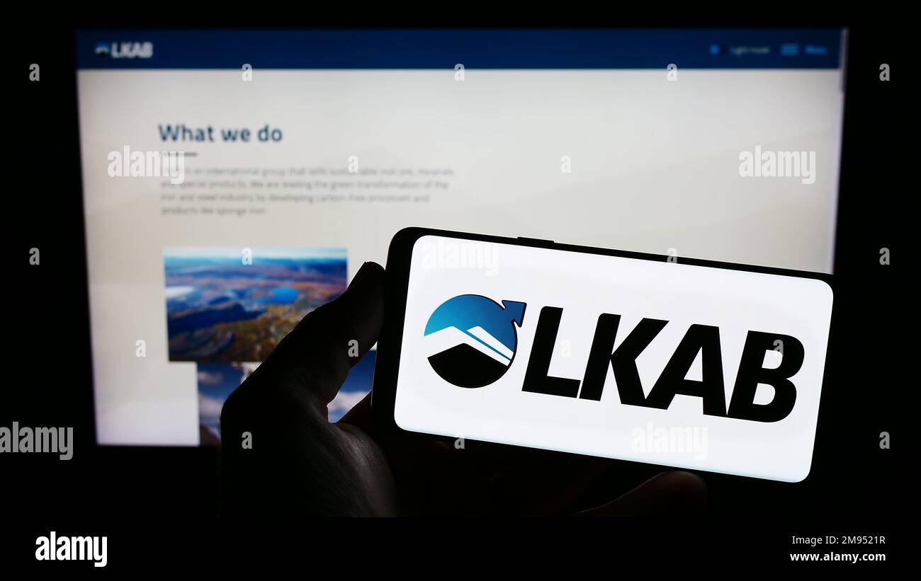 Persona che tiene il telefono cellulare con il logo della società Luossavaara-Kiirunavaara AB (LKAB) sullo schermo di fronte alla pagina web. Messa a fuoco sul display del telefono. Foto Stock