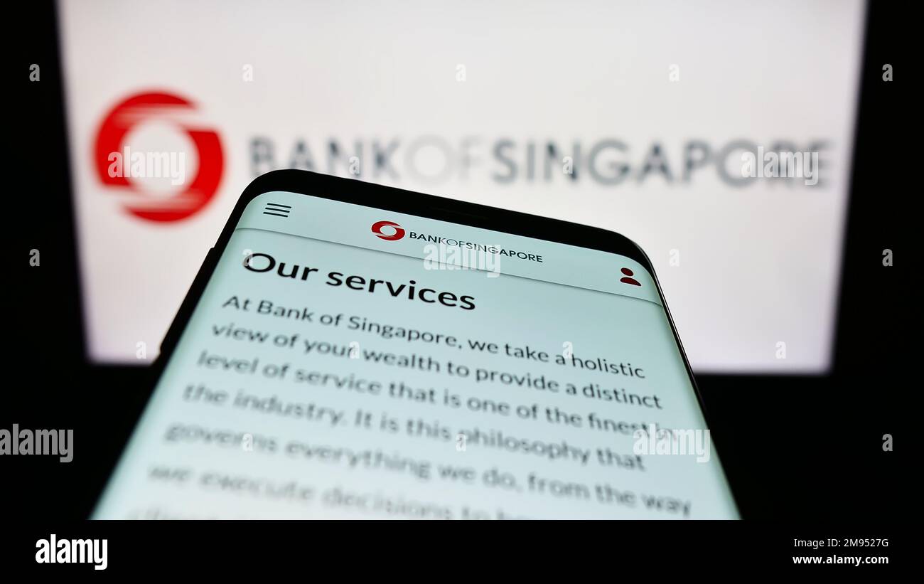 Telefono cellulare con sito web della società di servizi finanziari Banca di Singapore sullo schermo di fronte al logo aziendale. Messa a fuoco in alto a sinistra del display del telefono. Foto Stock