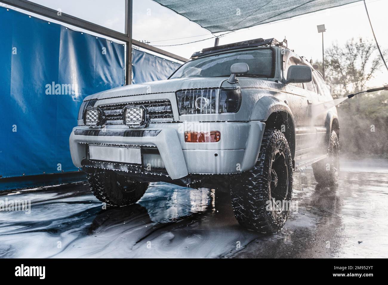 Grande auto SUV bianca in schiuma presso un autolavaggio self-service Foto Stock