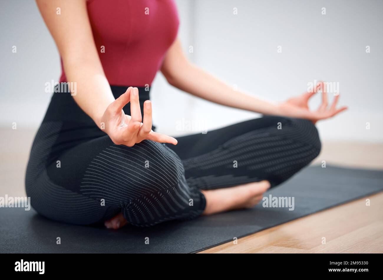 Calmare la mente e centrare i pensieri. una donna in posa loto durante una lezione di yoga. Foto Stock