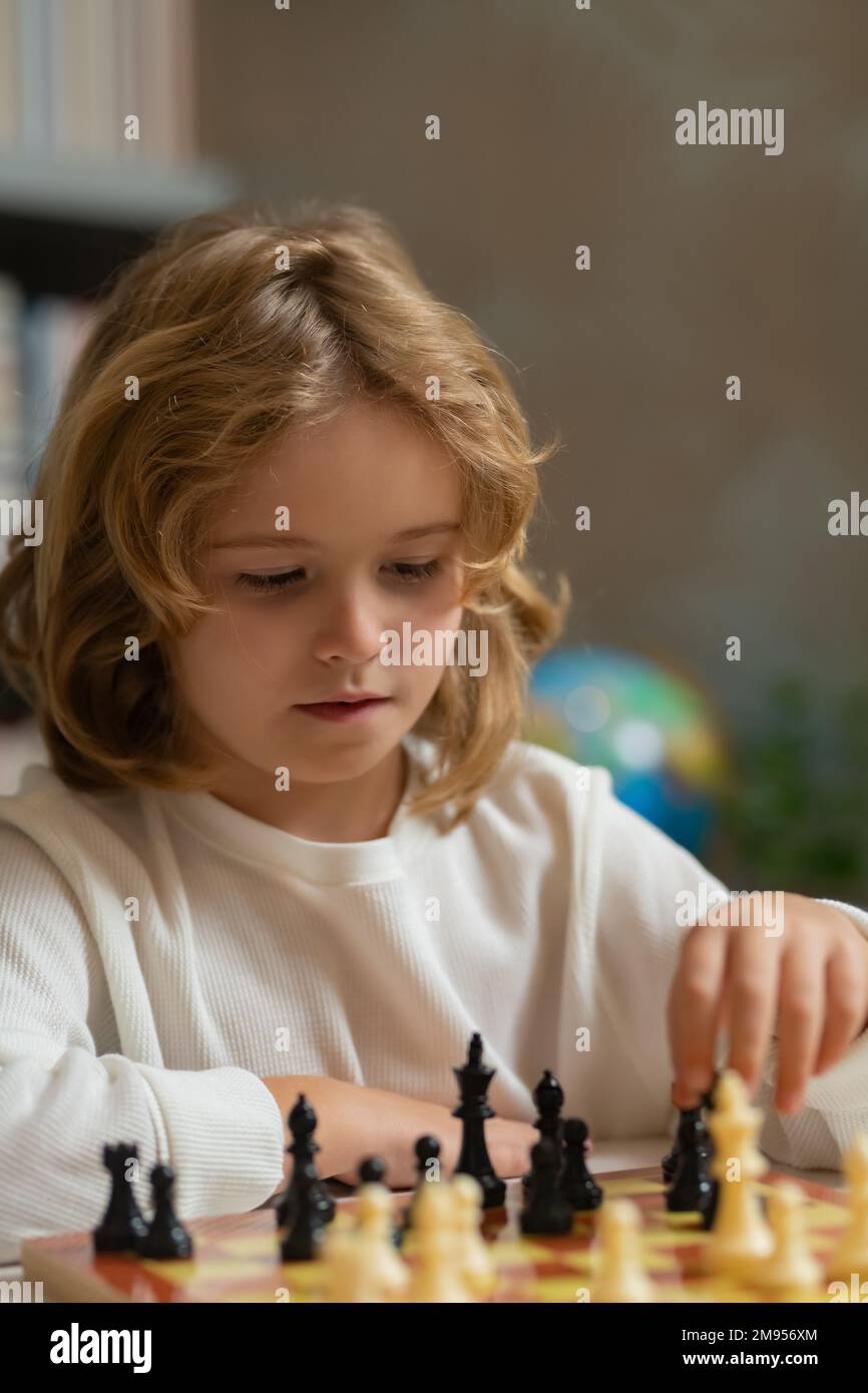 Scuola di scacchi. Il bambino pensa o progetta circa il gioco di scacchi in aula. Ragazzi di scuola intelligenti, intelligenti e intelligenti. Foto Stock