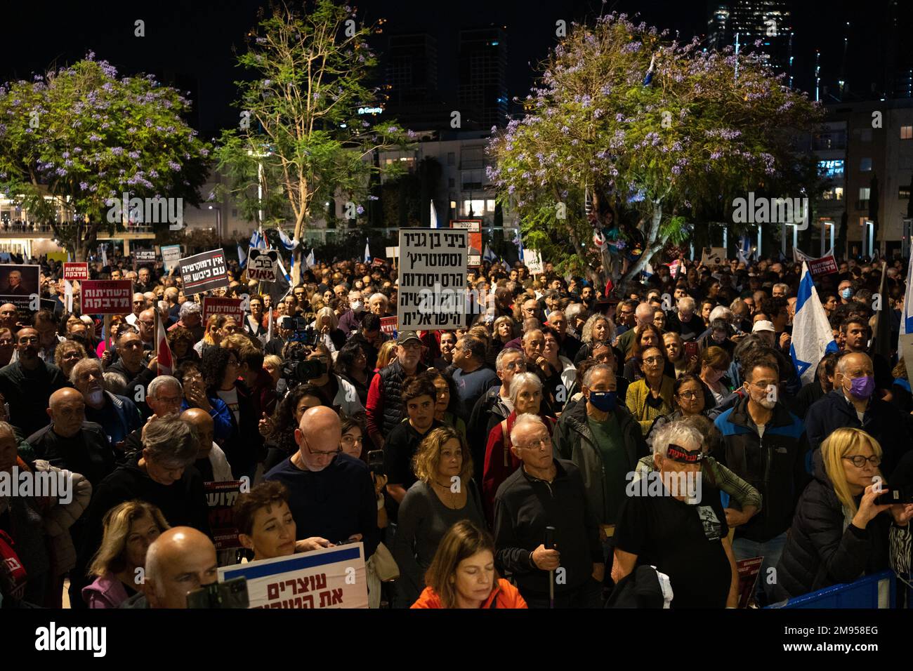 I manifestanti tengono i segni e sventolano le bandiere israeliane durante una manifestazione contro il nuovo piano di sistema giudiziario del governo israeliano che mira a indebolire la Corte Suprema del paese il 17th 2022 dicembre a Tel Aviv, Israele. I sostenitori delle libertà civili accusano il nuovo governo di dichiarare guerra contro il sistema giuridico, dicendo che il piano proposto metterà in pericolo i diritti delle minoranze e metterà in pericolo la democrazia del paese. Foto Stock