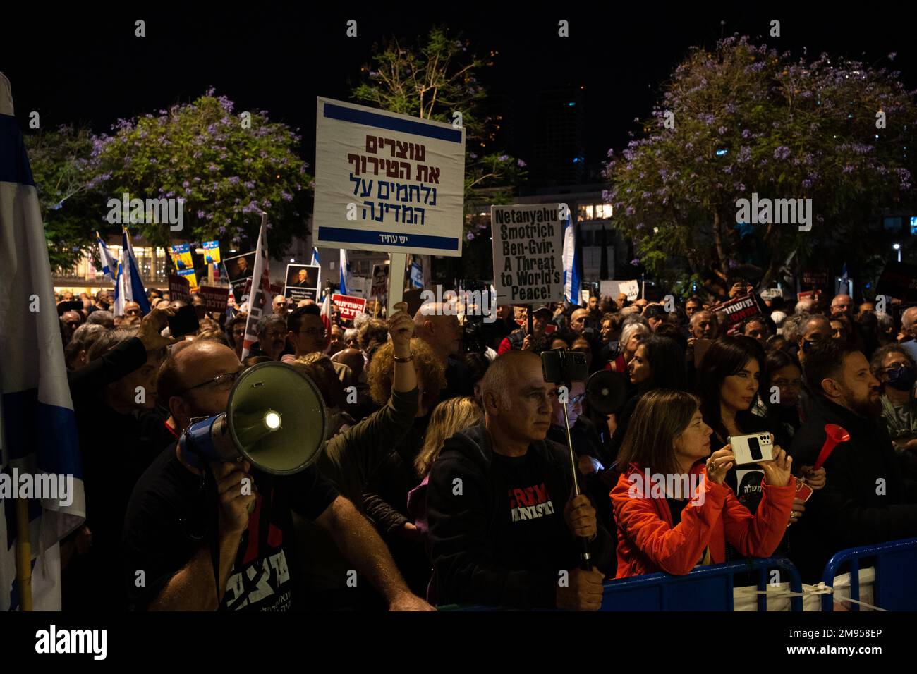 I manifestanti tengono i segni e sventolano le bandiere israeliane durante una manifestazione contro il nuovo piano di sistema giudiziario del governo israeliano che mira a indebolire la Corte Suprema del paese il 17th 2022 dicembre a Tel Aviv, Israele. I sostenitori delle libertà civili accusano il nuovo governo di dichiarare guerra contro il sistema giuridico, dicendo che il piano proposto metterà in pericolo i diritti delle minoranze e metterà in pericolo la democrazia del paese. Foto Stock