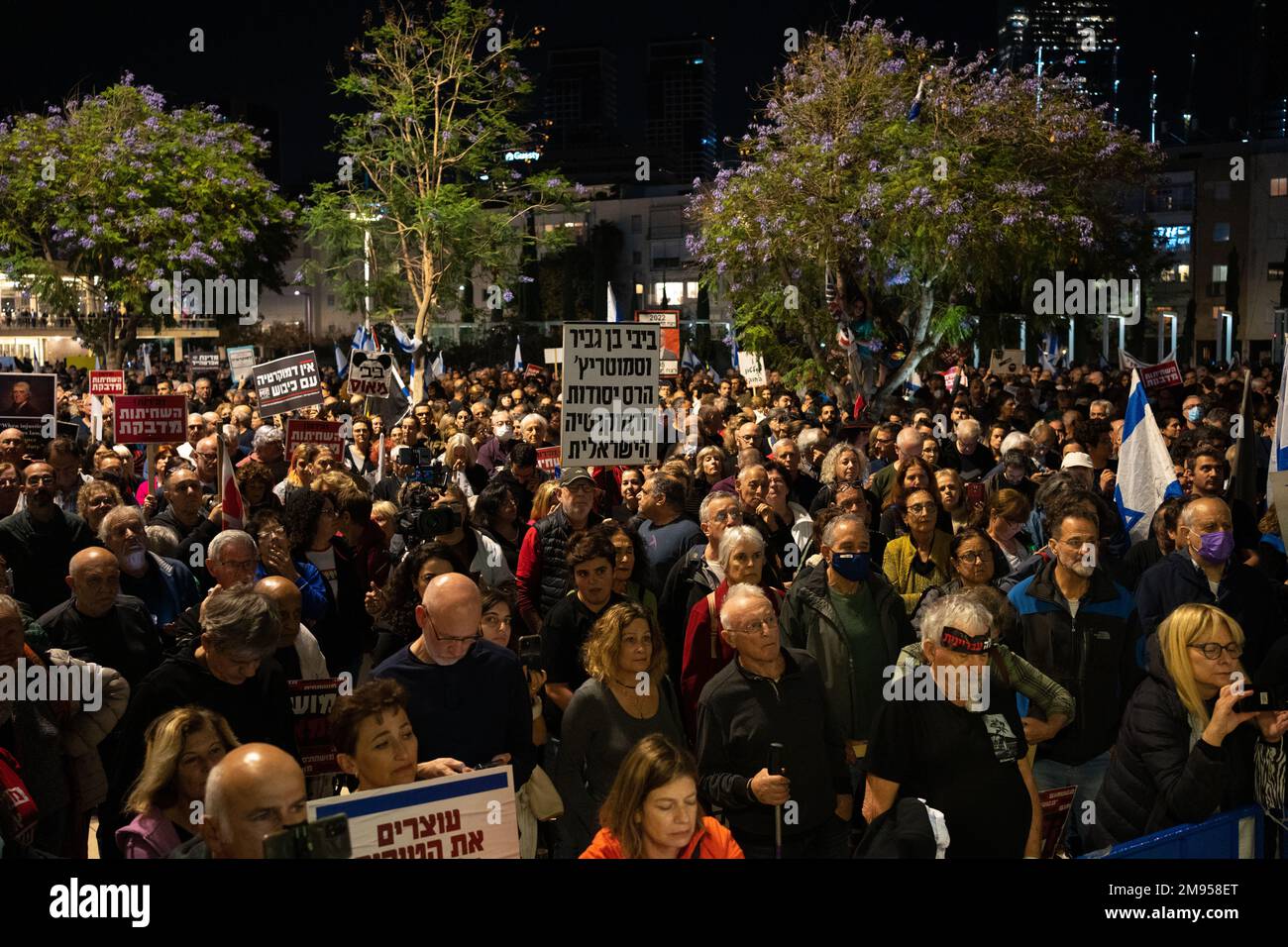 I manifestanti tengono i segni e sventolano le bandiere israeliane durante una manifestazione contro il nuovo piano di sistema giudiziario del governo israeliano che mira a indebolire la Corte Suprema del paese il 17th 2022 dicembre a Tel Aviv, Israele. I sostenitori delle libertà civili accusano il nuovo governo di dichiarare guerra contro il sistema giuridico, dicendo che il piano proposto metterà in pericolo i diritti delle minoranze e metterà in pericolo la democrazia del paese. Foto Stock