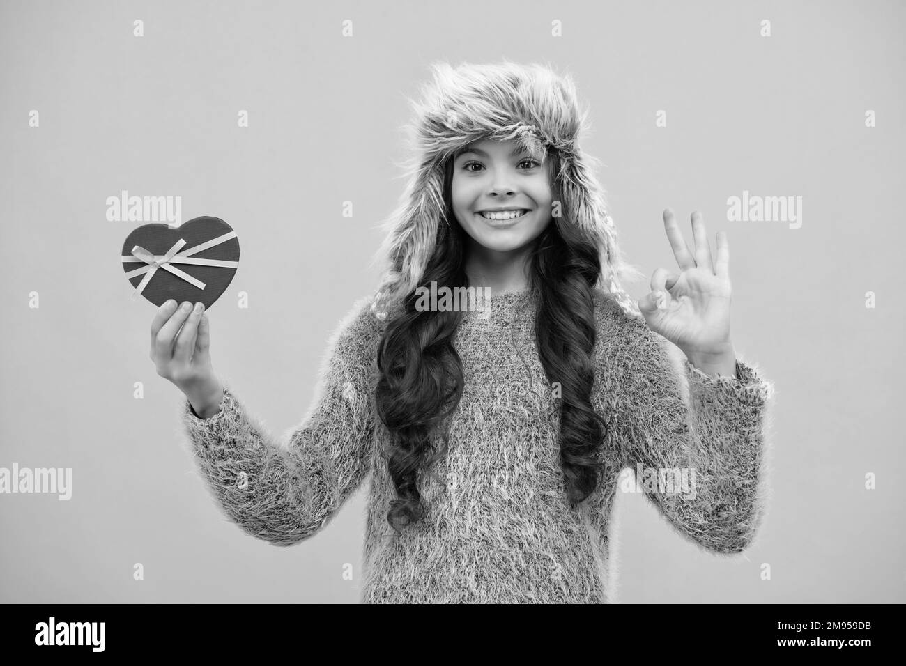 Bambino adolescente in inverno indossare scatole regalo che celebra felice anno nuovo o Natale. Vacanza invernale per bambini. Faccia felice della ragazza, positiva e sorridente Foto Stock