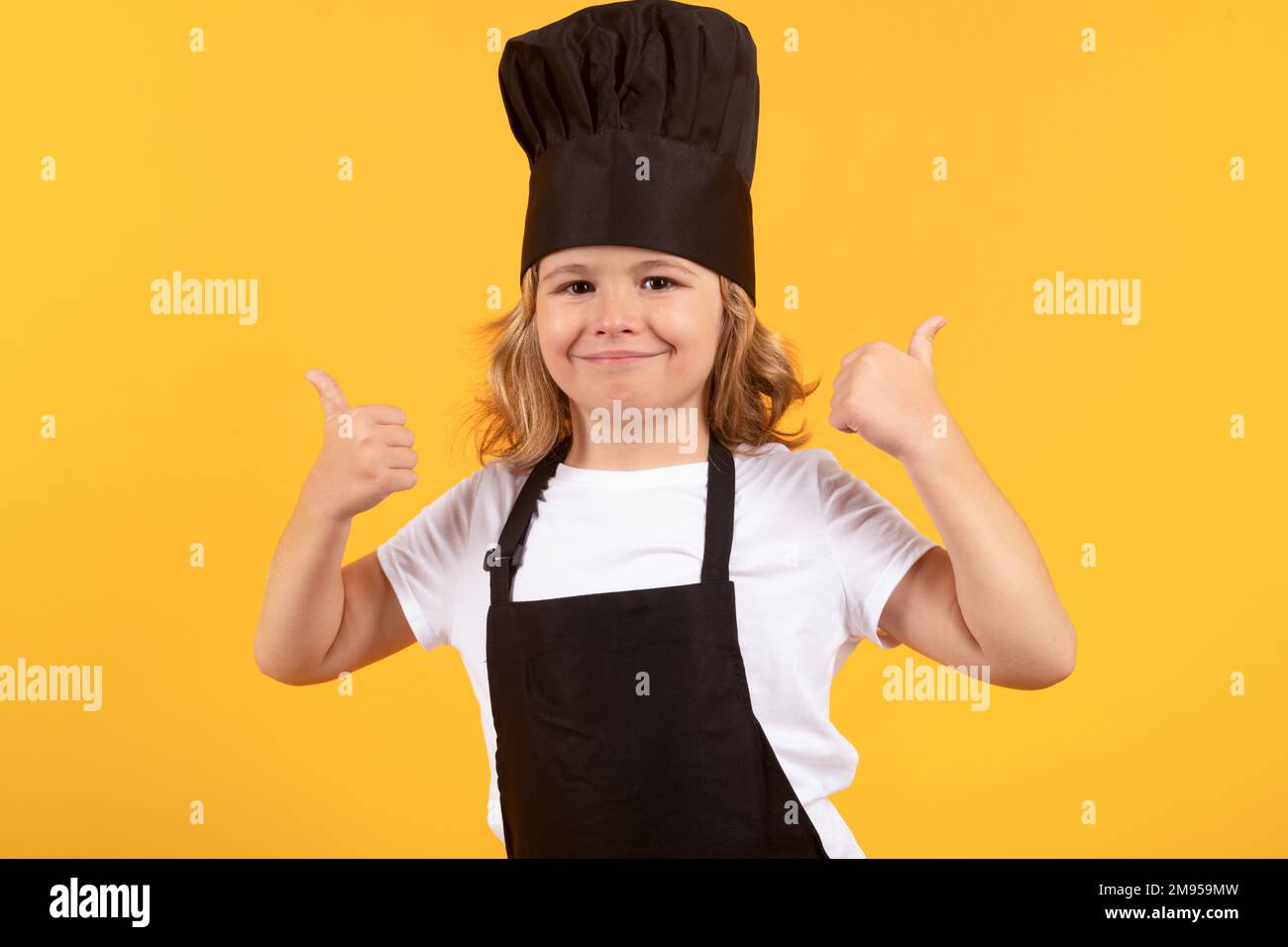 Bambino che indossa la divisa del fornello e il cappello dello chef che  prepara il cibo in cucina, studio ritratto. Cucina, cucina e cibo per  bambini Foto stock - Alamy