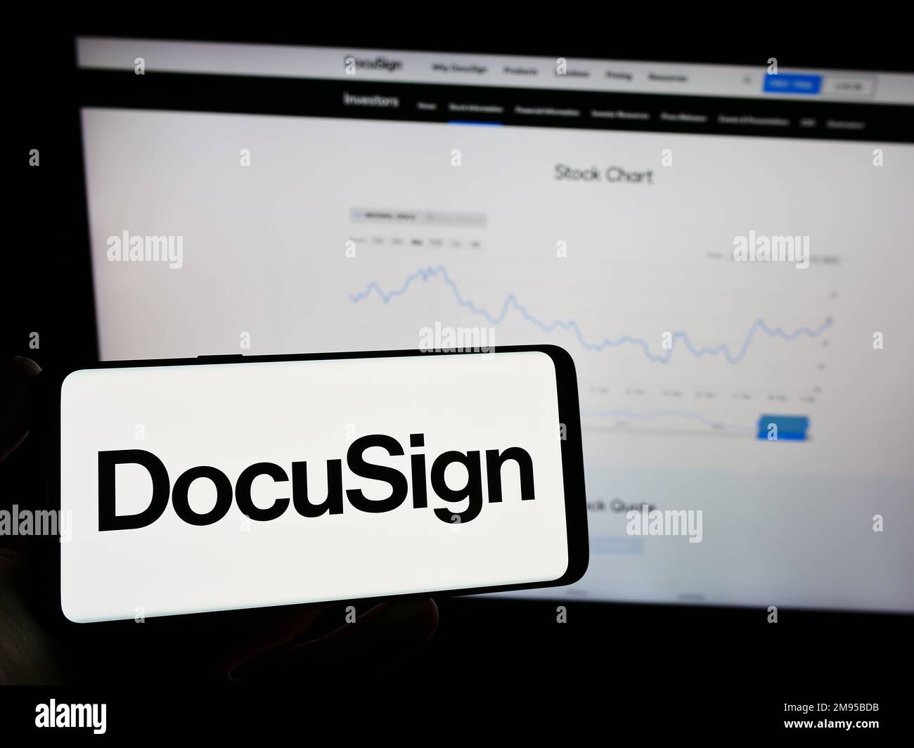 Persona che detiene uno smartphone con il logo della società americana di firma elettronica DocuSign Inc. Sullo schermo di fronte al sito Web. Messa a fuoco sul display del telefono. Foto Stock