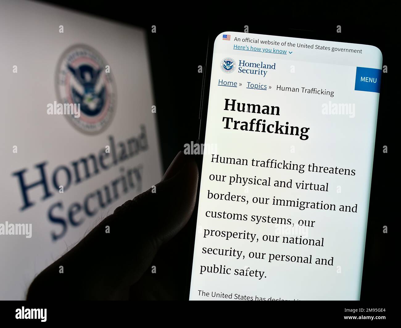 Persona che tiene il cellulare con la pagina web del Dipartimento di sicurezza interna degli Stati Uniti (DHS) sullo schermo di fronte al sigillo. Messa a fuoco al centro del display del telefono. Foto Stock