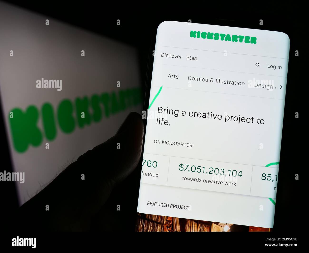 Persona che tiene il cellulare con la pagina web della piattaforma di crowdfunding US Kickstarter PBC sullo schermo di fronte al logo. Messa a fuoco al centro del display del telefono. Foto Stock
