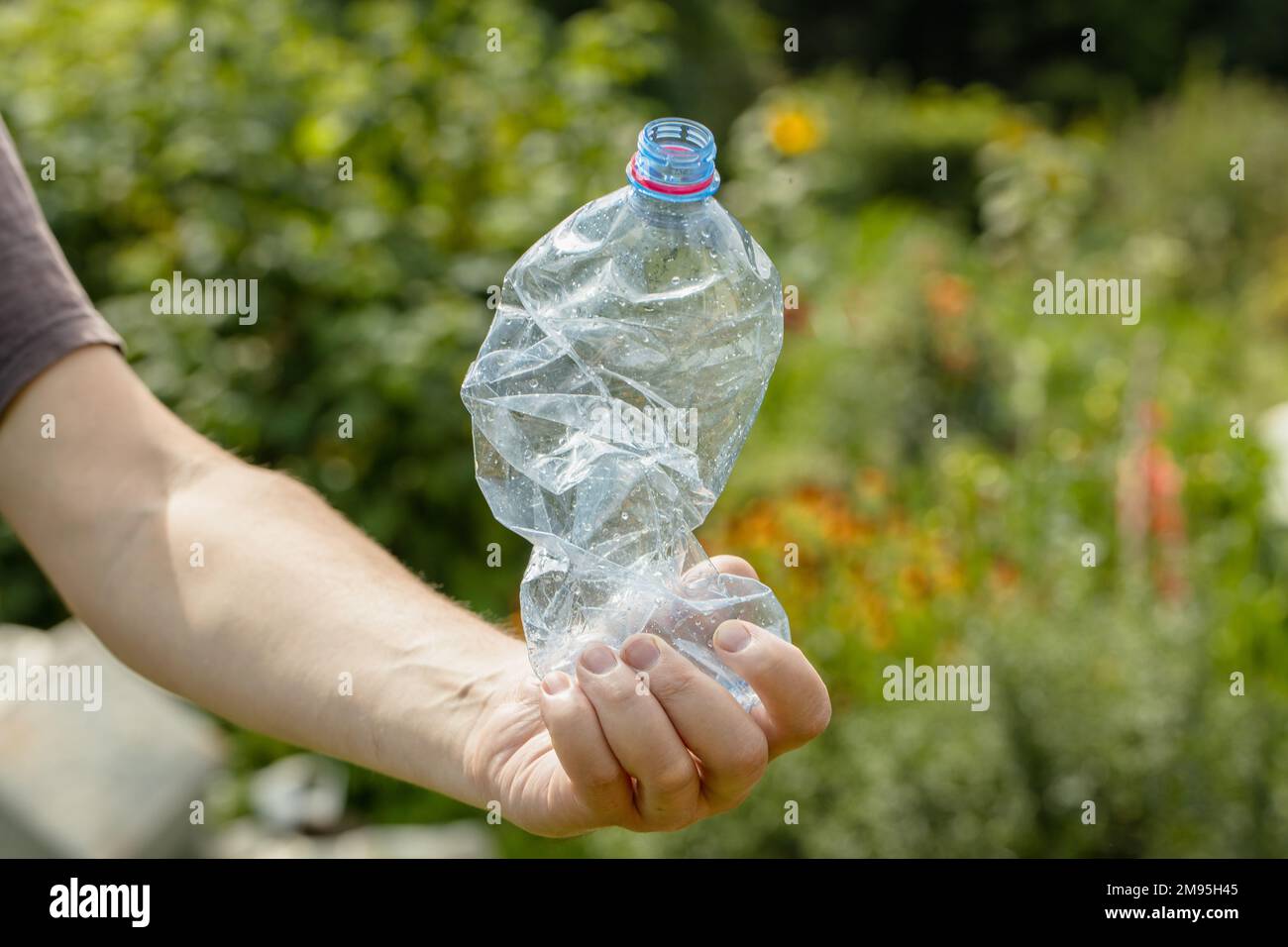 Mano Che Schiaccia Bottiglia Di Plastica Vuota Fotografia Stock
