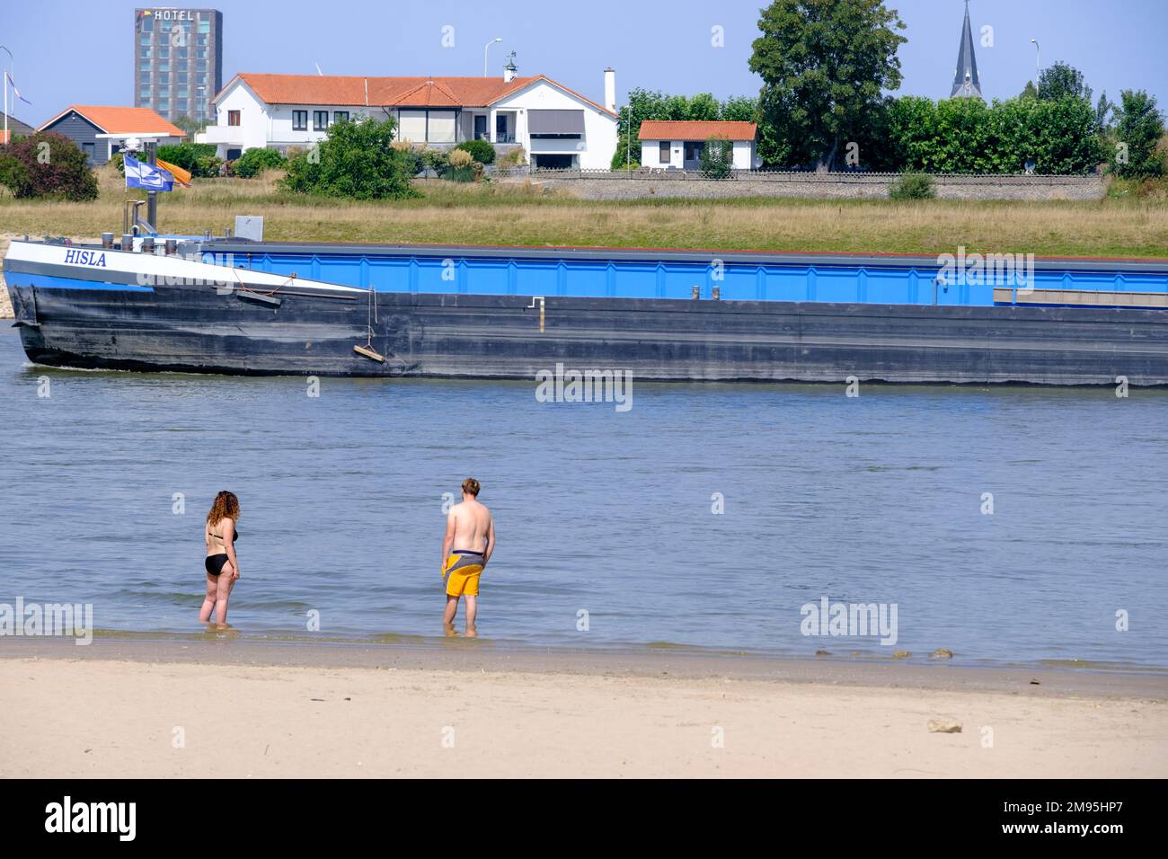 Paesi Bassi,Ooyse Schependom, 23 agosto 2022: Persone sulle rive del fiume Waal, delta del Reno, durante la siccità dell'estate 2022. Persone che nuotano Foto Stock