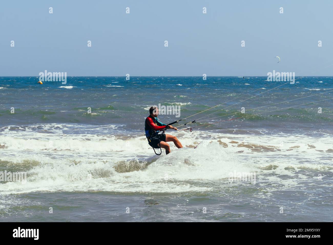 MUI NE, VIETNAM - 4 MARZO 2017: Il kitesurfer maschile si muove sul bordo sulle onde del mare Foto Stock