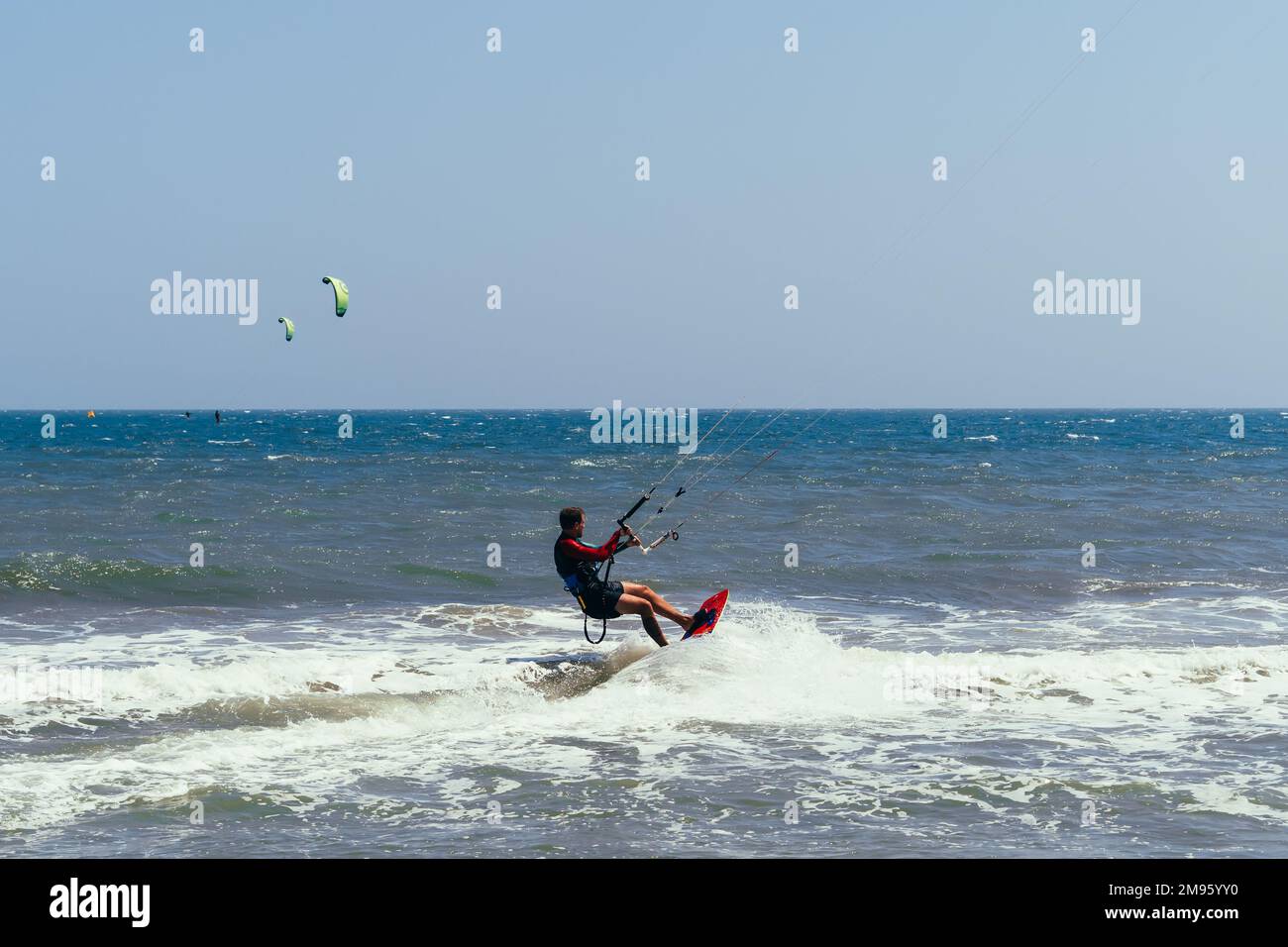 MUI NE, VIETNAM - 4 MARZO 2017: Il kitesurfer maschile si muove sul bordo sulle onde del mare Foto Stock