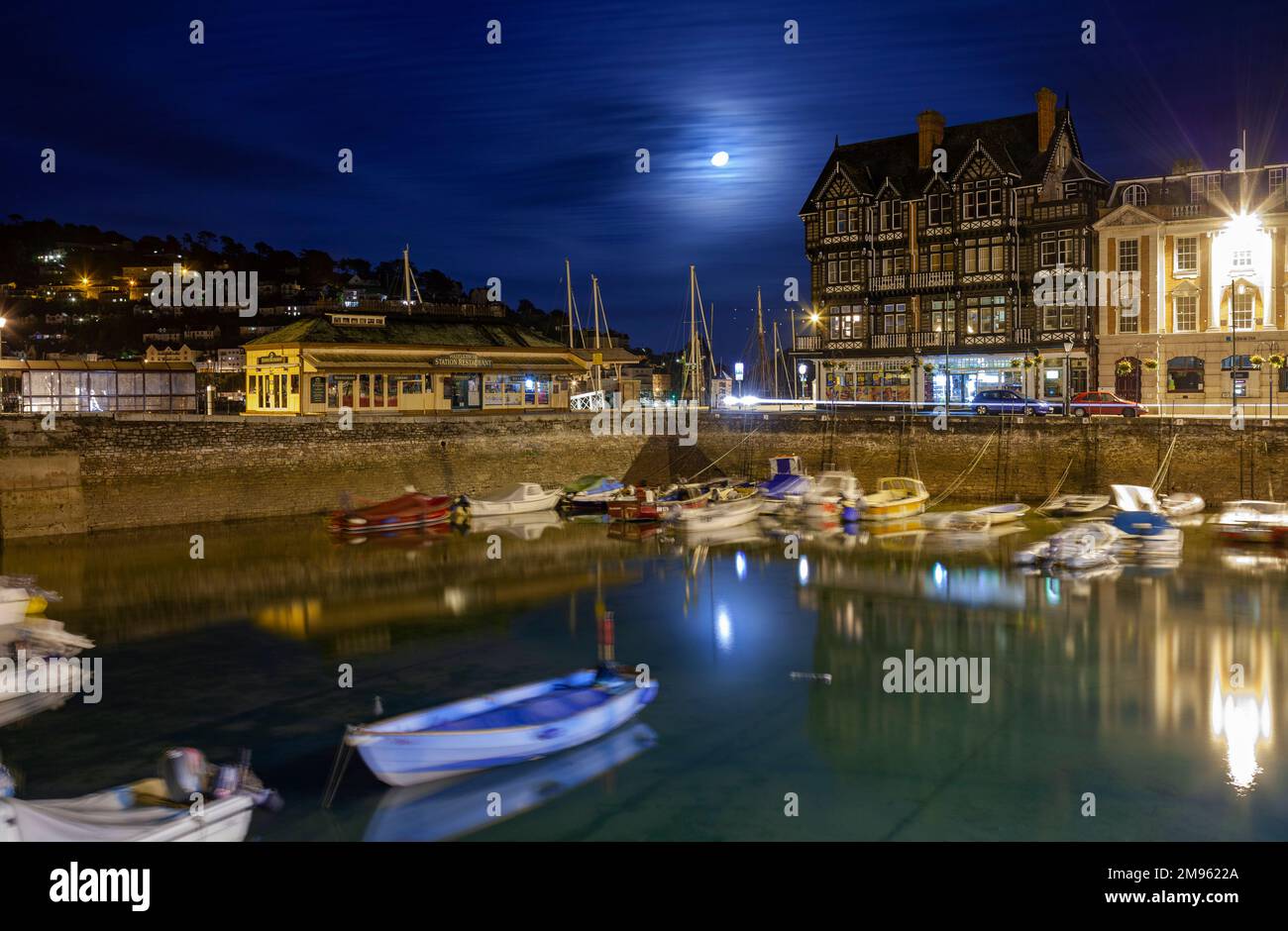 Regno Unito, Inghilterra, Devon, Dartmouth, il Boat Float di notte con la storica stazione ferroviaria e barche ormeggiate Foto Stock