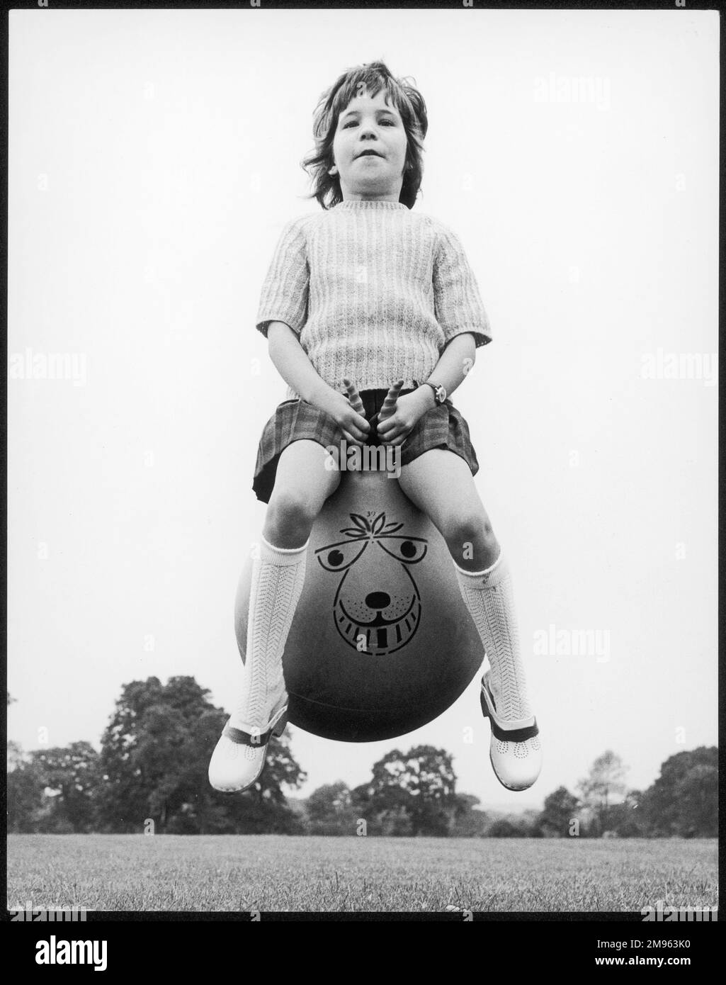 Una ragazza rimbalza in alto nell'aria sulla sua spacehopper, uno dei nuovi giocattoli classici della 1970s. (Immagine 2 su 4) Foto Stock
