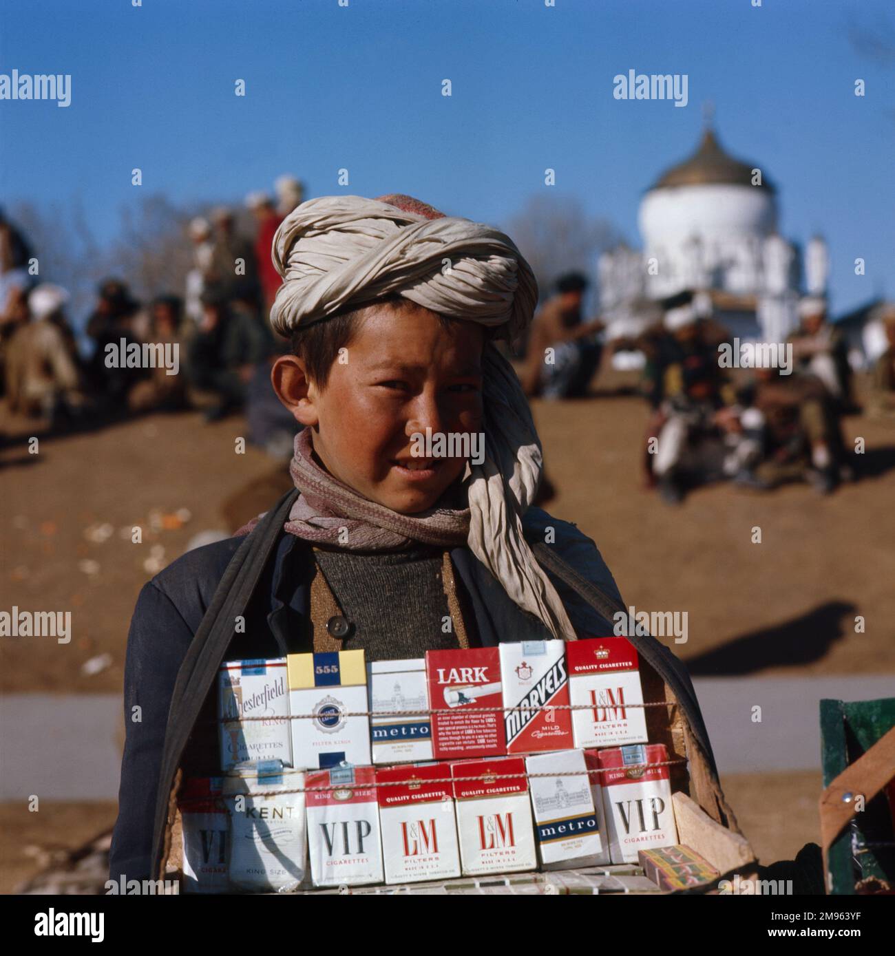 Un ragazzo afghano vende sigarette straniere. Foto Stock