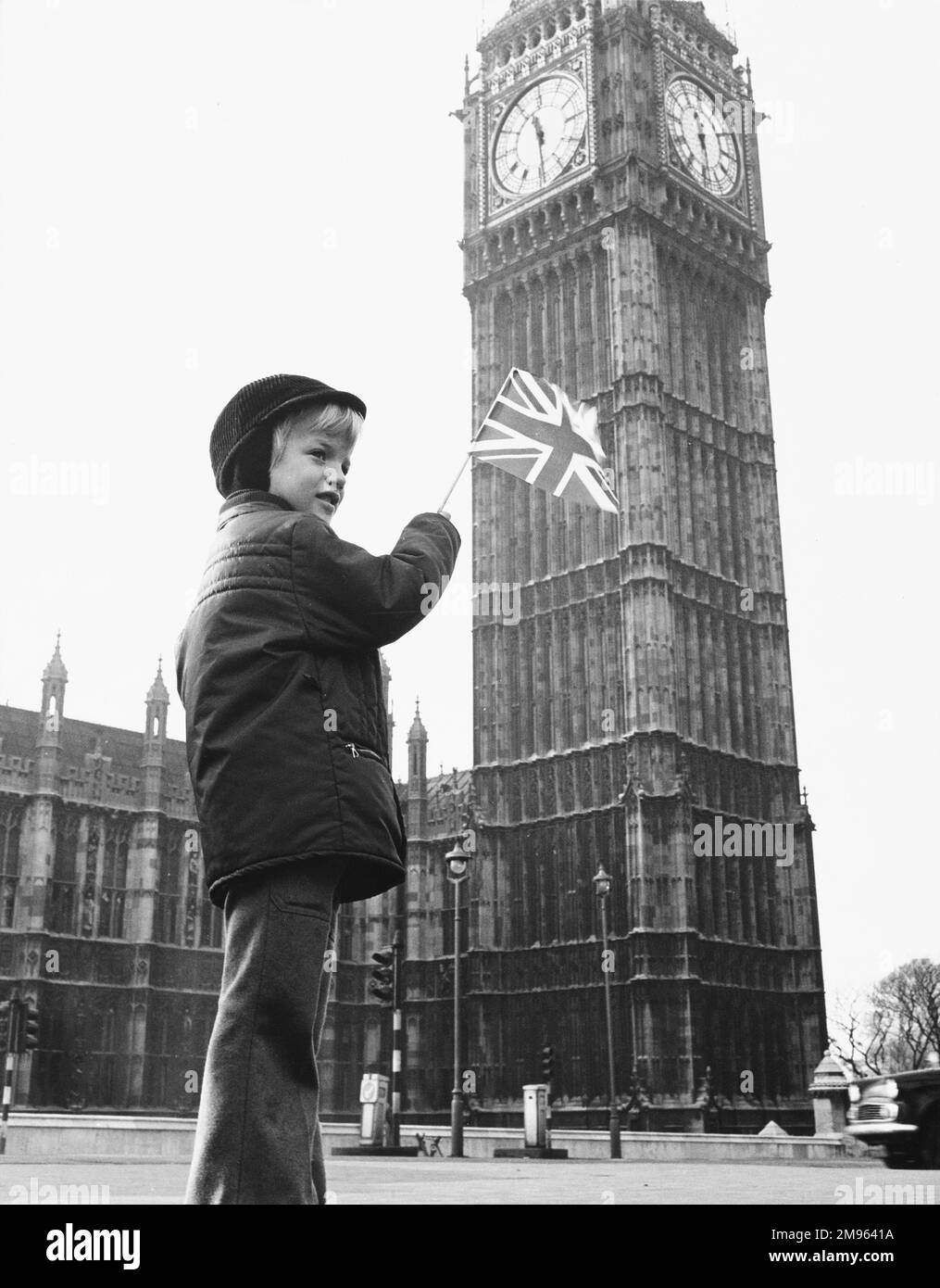 Un ragazzo sventola una bandiera alla base della torre di Santo Stefano che ospita il Big ben Foto Stock