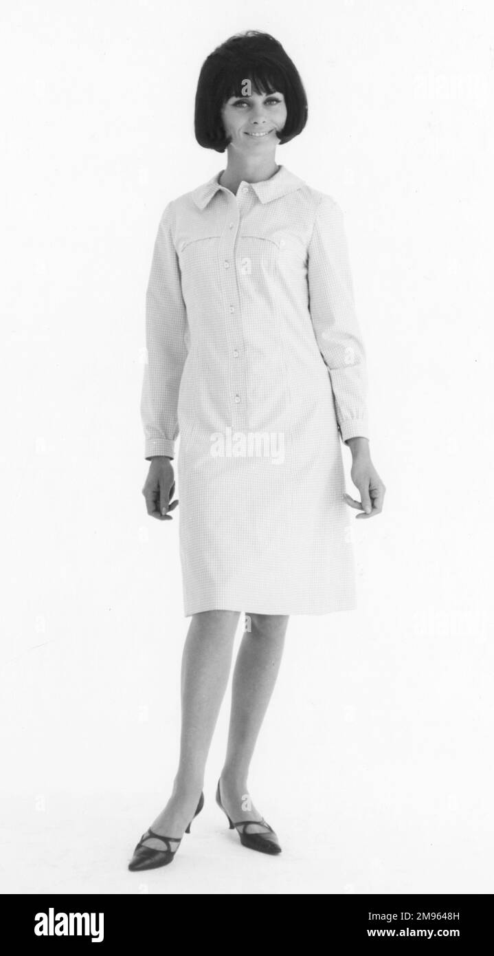 Ritratto a tutta lunghezza di una donna che modella un abito piuttosto semplice. Foto Stock