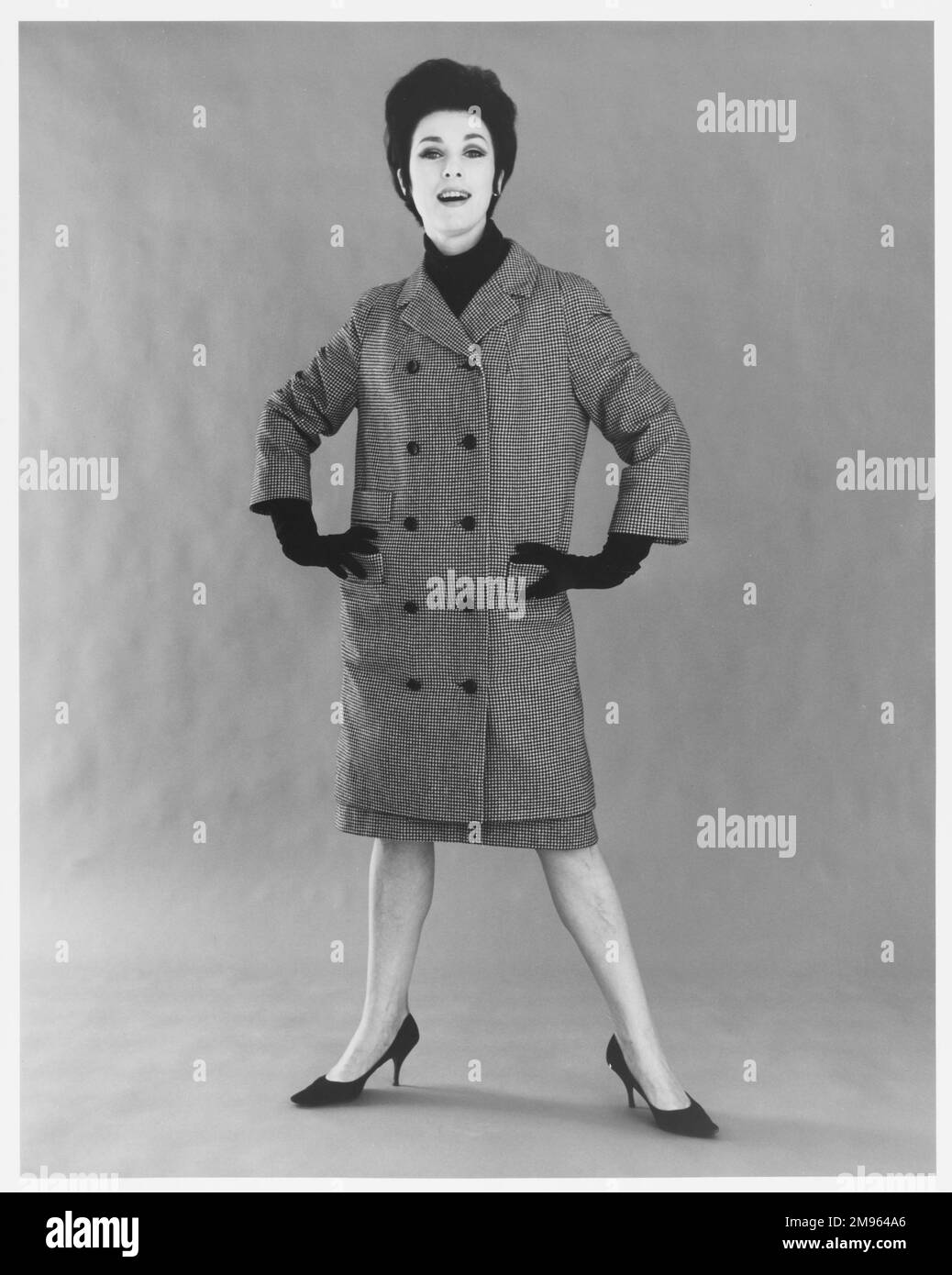 Ritratto integrale di una donna in un camice di ginocchio con gonna coordinata. Foto Stock