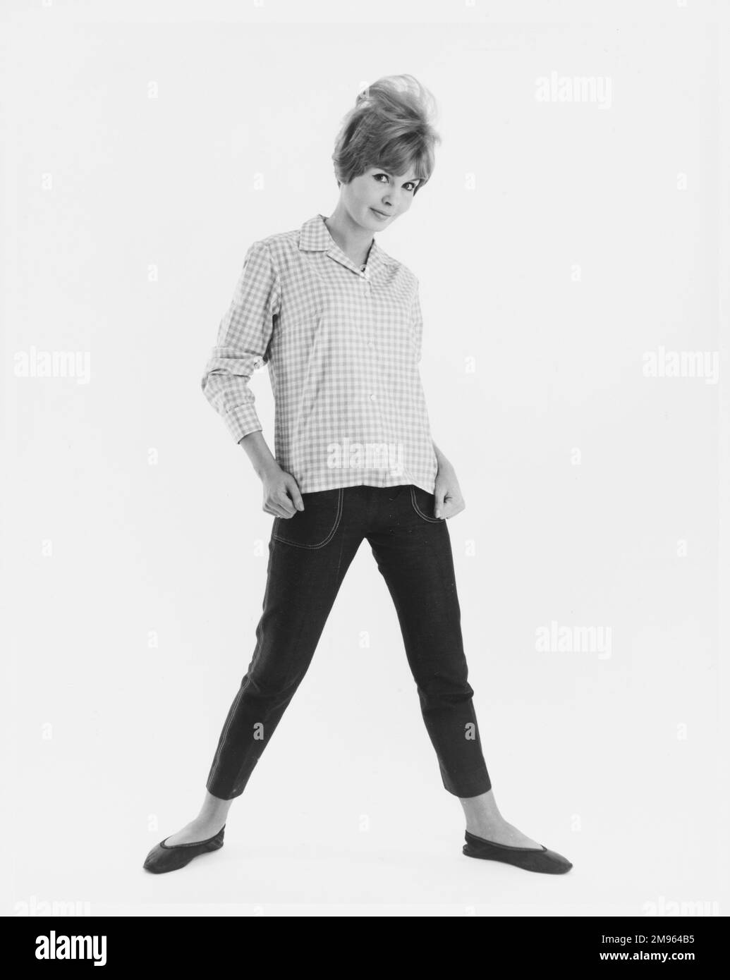 Ritratto a tutta lunghezza di un modello in una camicia a quadri e jeans corti, in posa per la fotocamera. Foto Stock